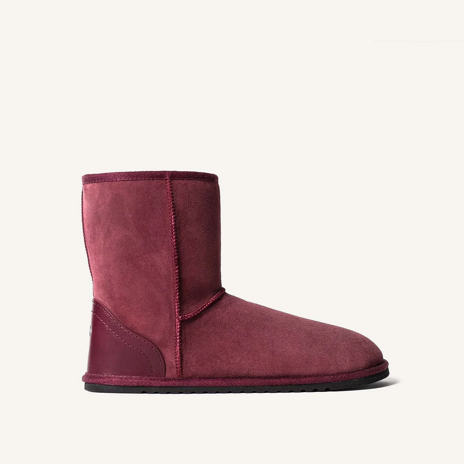 Sheepskin boot slippers with hard sole in plum red.