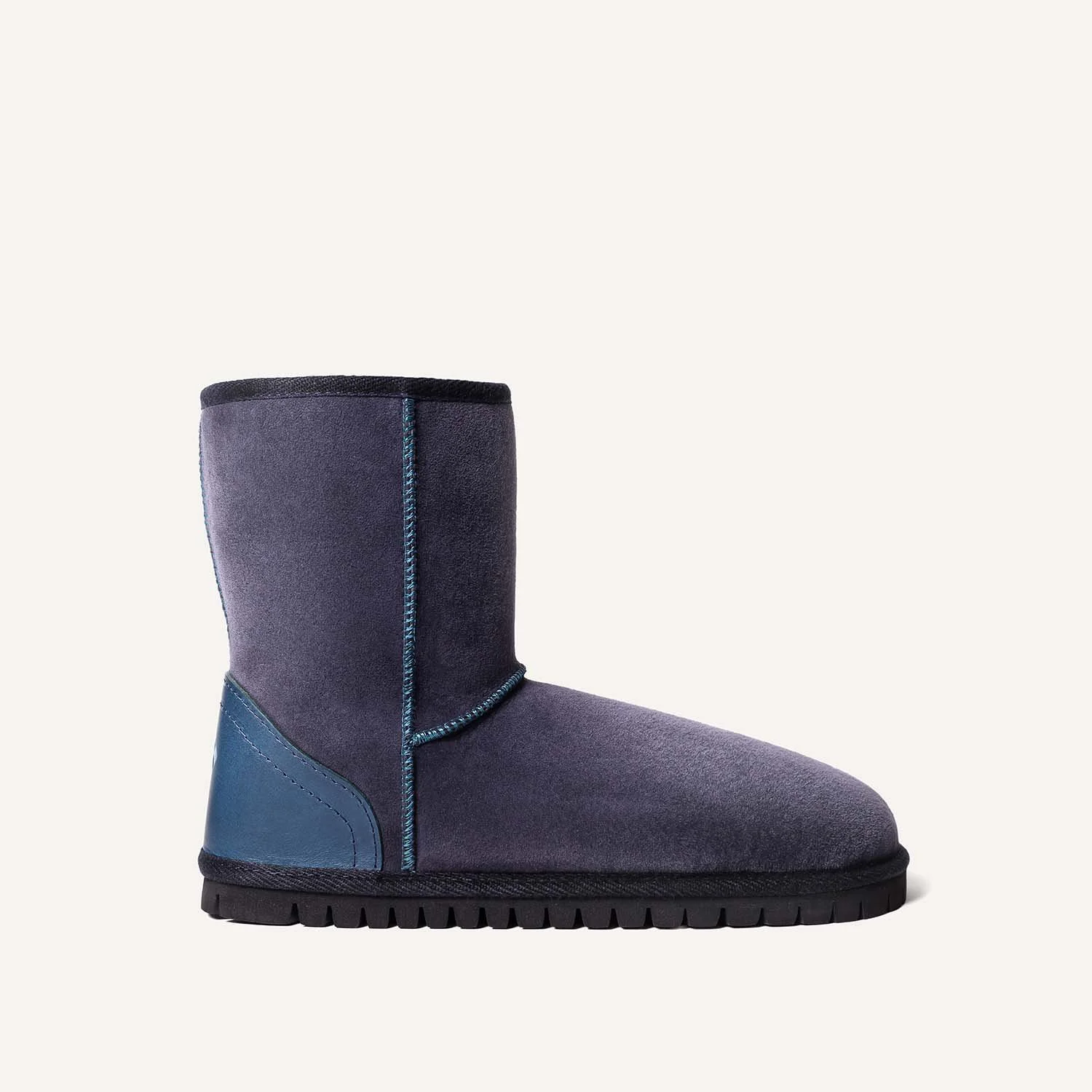 Profile view of navy and teal sheepskin boot.