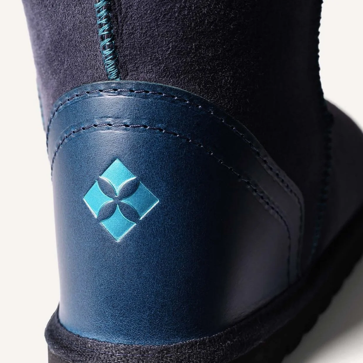 Beautiful metallic teal logo embossed onto darker teal leather heel.