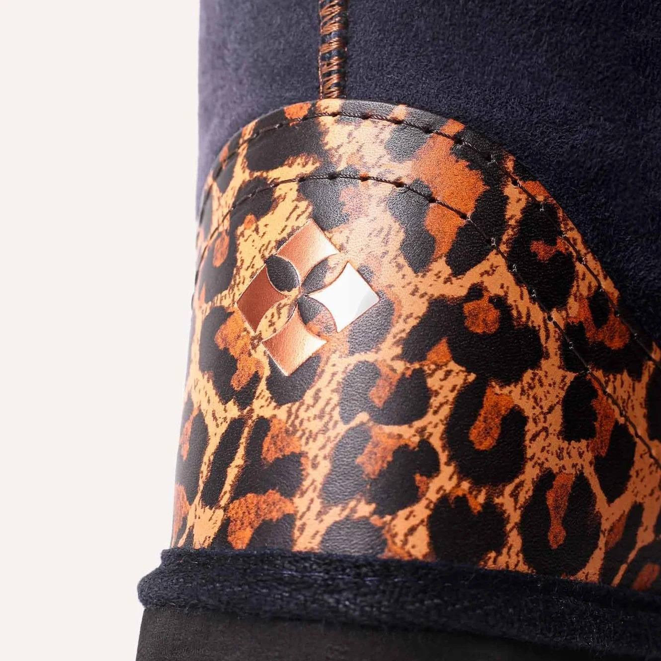 Close up of copper logo embossed onto leopard print leather.
