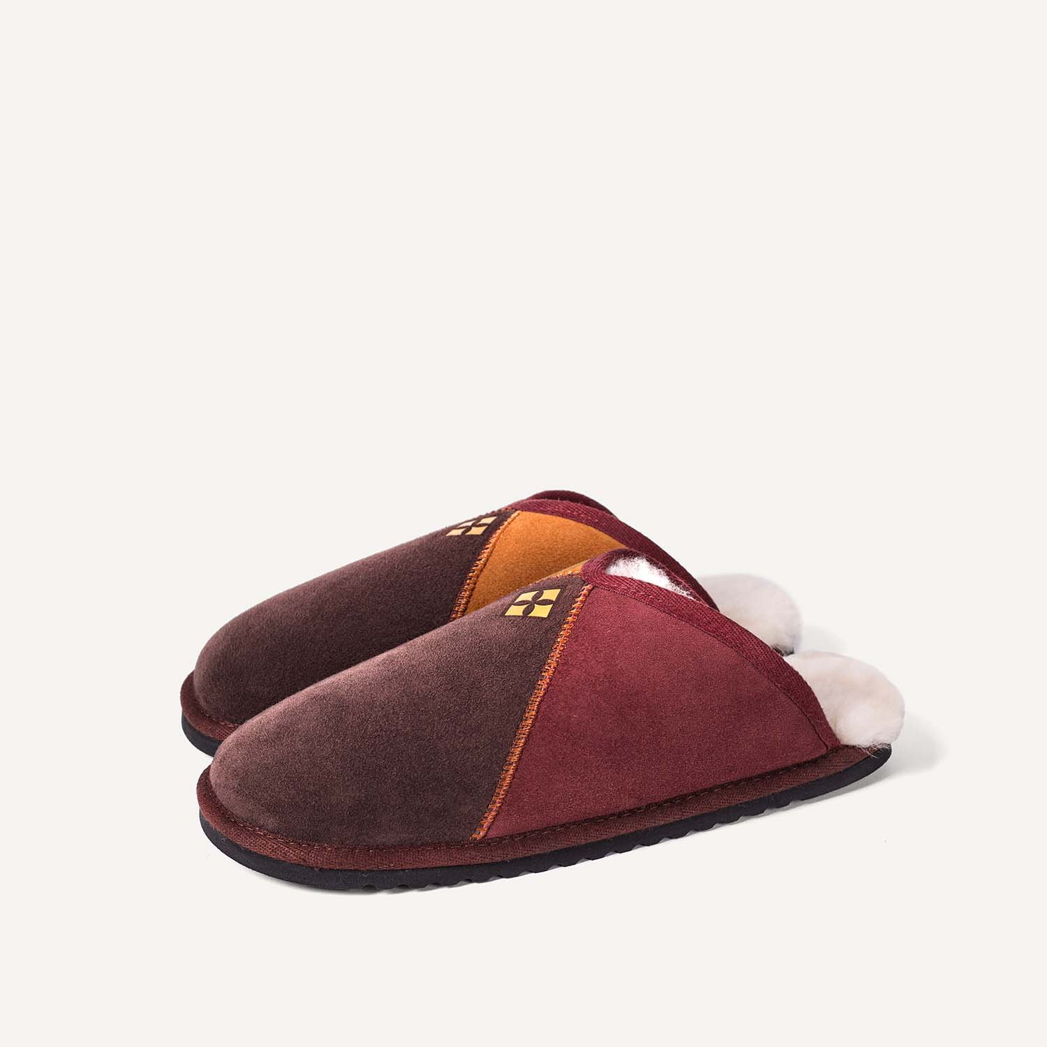 Pair of slip on slippers in brown, red, orange.