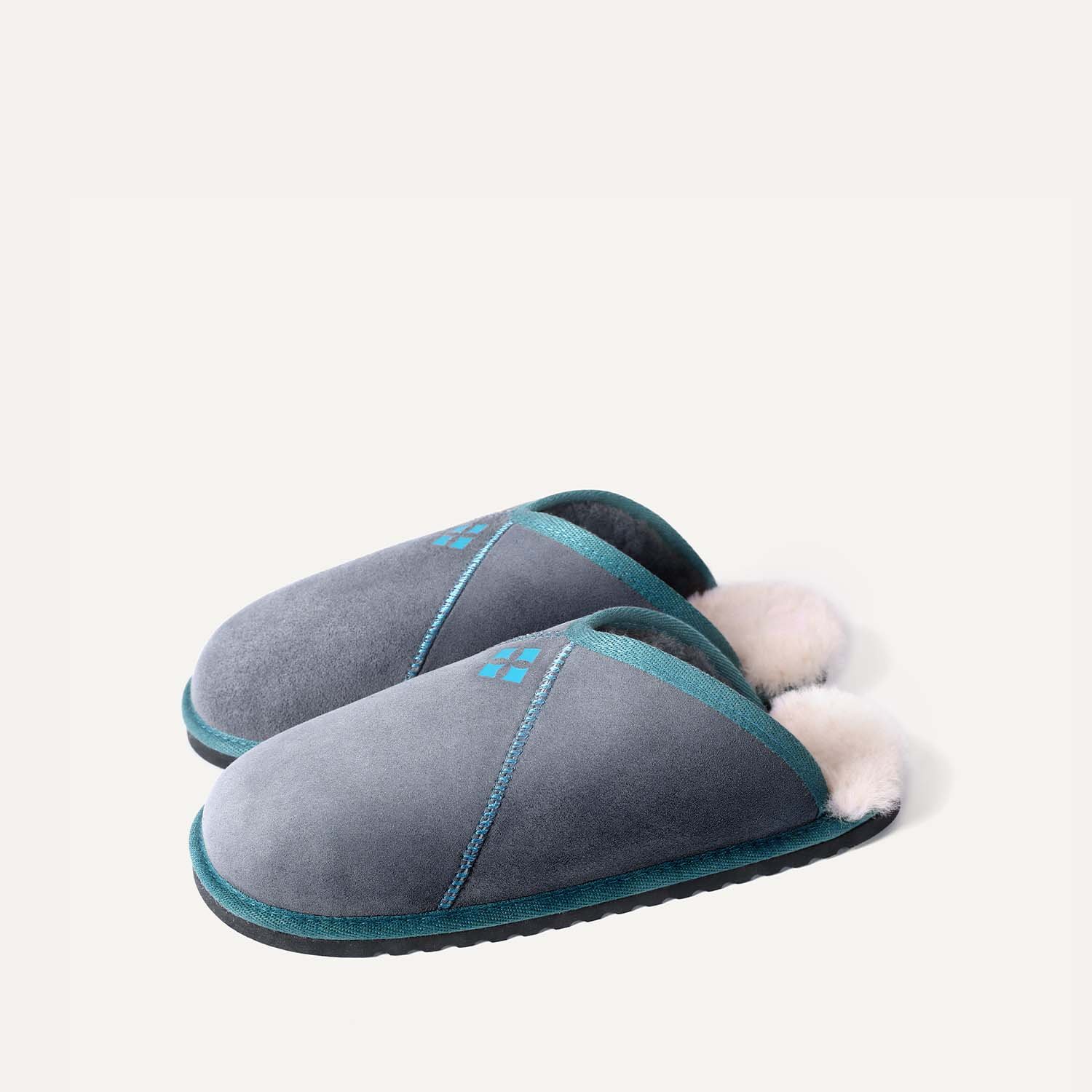A pair of grey and teal sheepskin slippers.