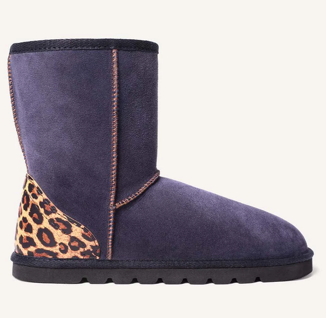 Profile view of navy blue sheepskin boot with leopard print heel.