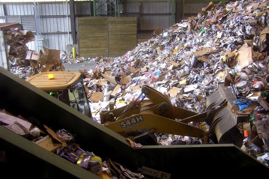  One front-end loader pushes recyclables onto first conveyor belt while another larger front-end loader pushes dumped recyclables onto central pile - Ocean County Recycling Education Center, June 2010 
