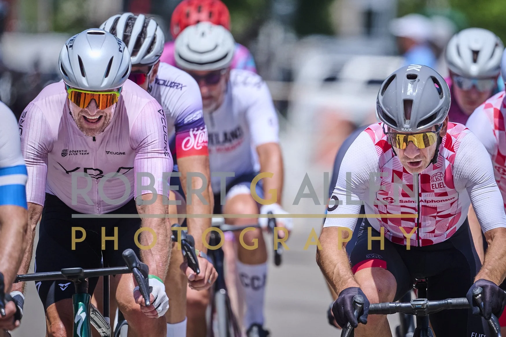 Cyclists wearing helmets and colorful jerseys participating in a race, focused and intense.
