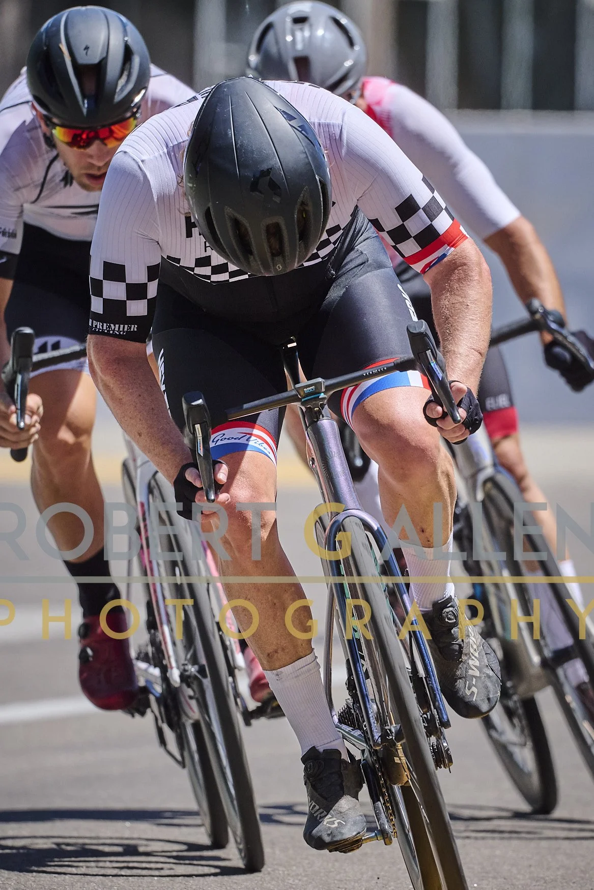 Cyclists racing in a competitive cycling event, wearing helmets and cycling gear.