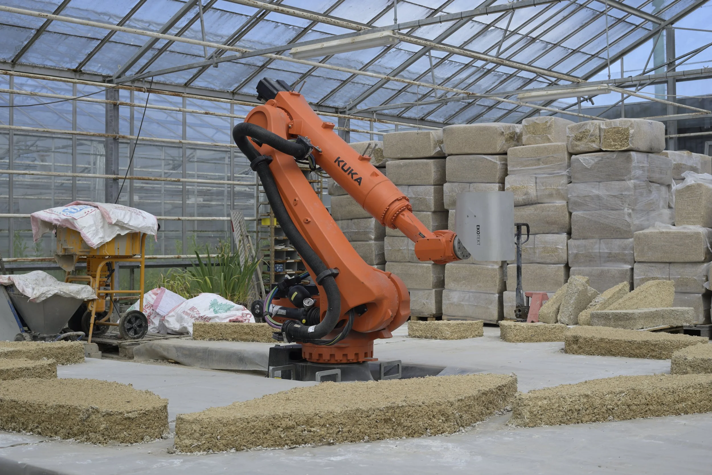 Ekotekt industrial robot surrounded by 3D-printed hempcrete formwork pieces in Denmark.