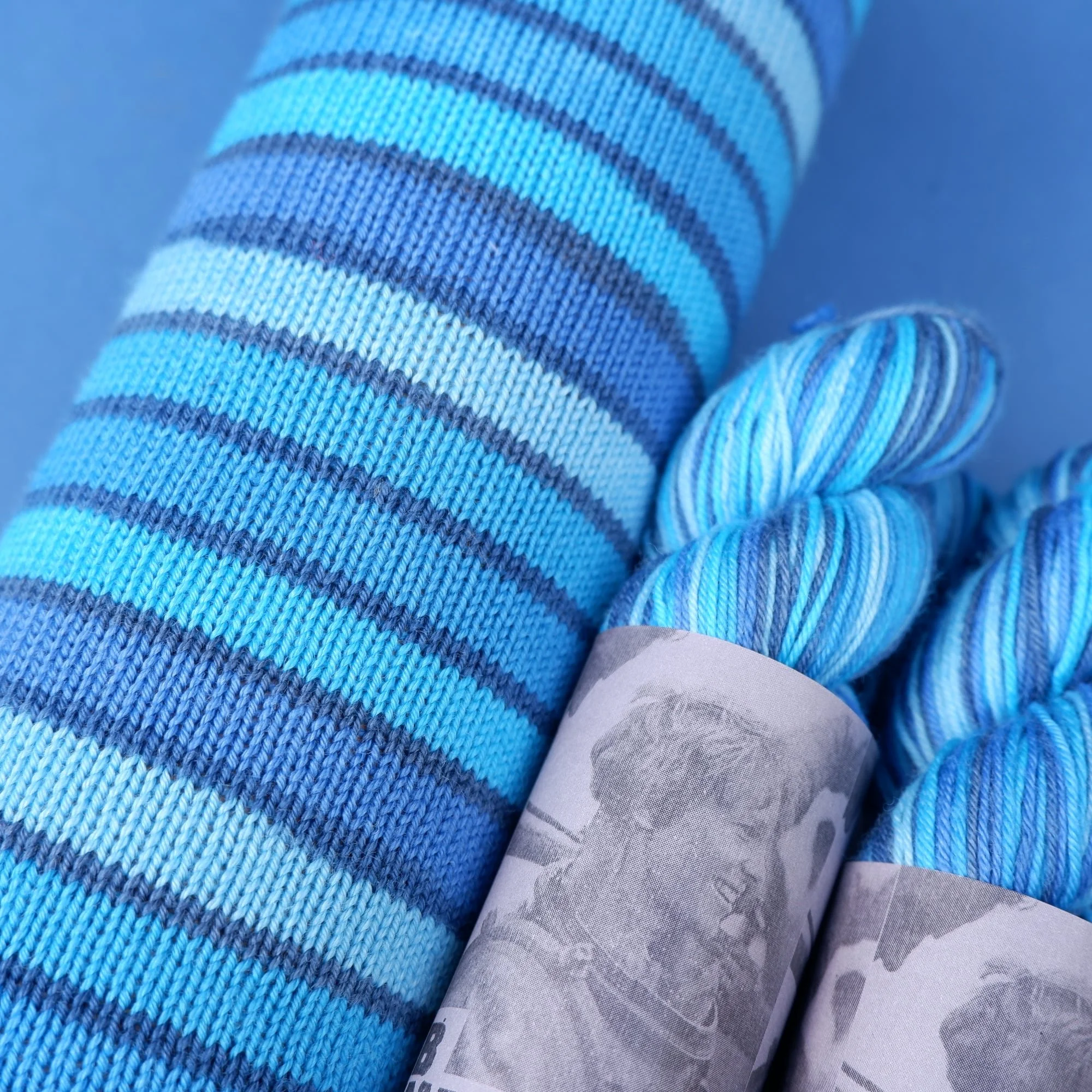 10 stripe hand dyed self-striping yarn cool shades of blue separated by a micro navy stripe