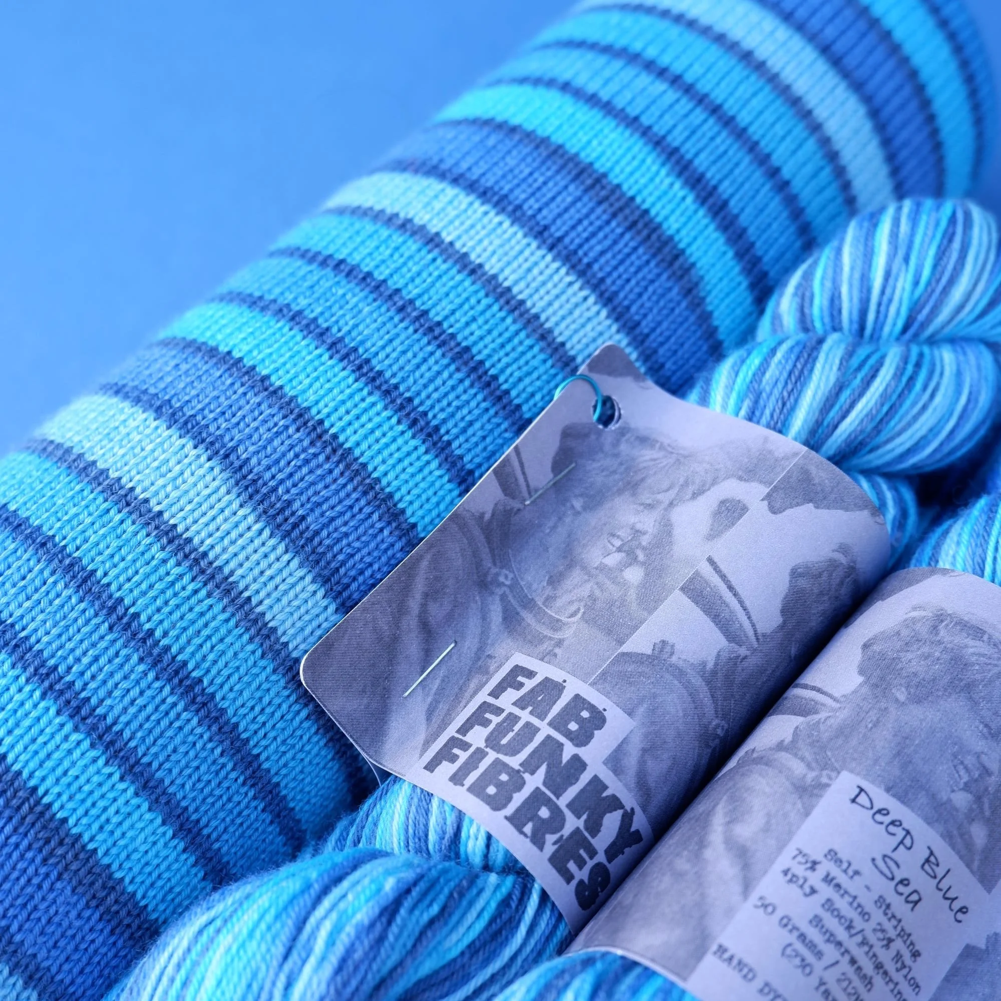 10 stripe hand dyed self-striping yarn cool shades of blue separated by a micro navy stripe