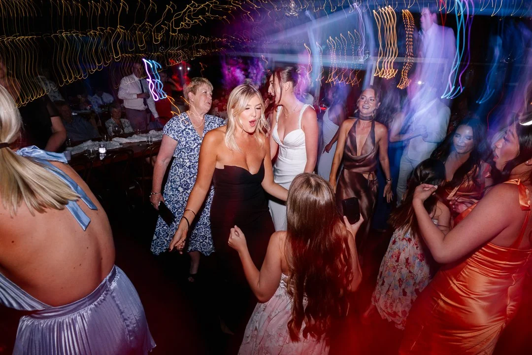 People dancing and enjoying themselves at a lively party or celebration with colorful lights.