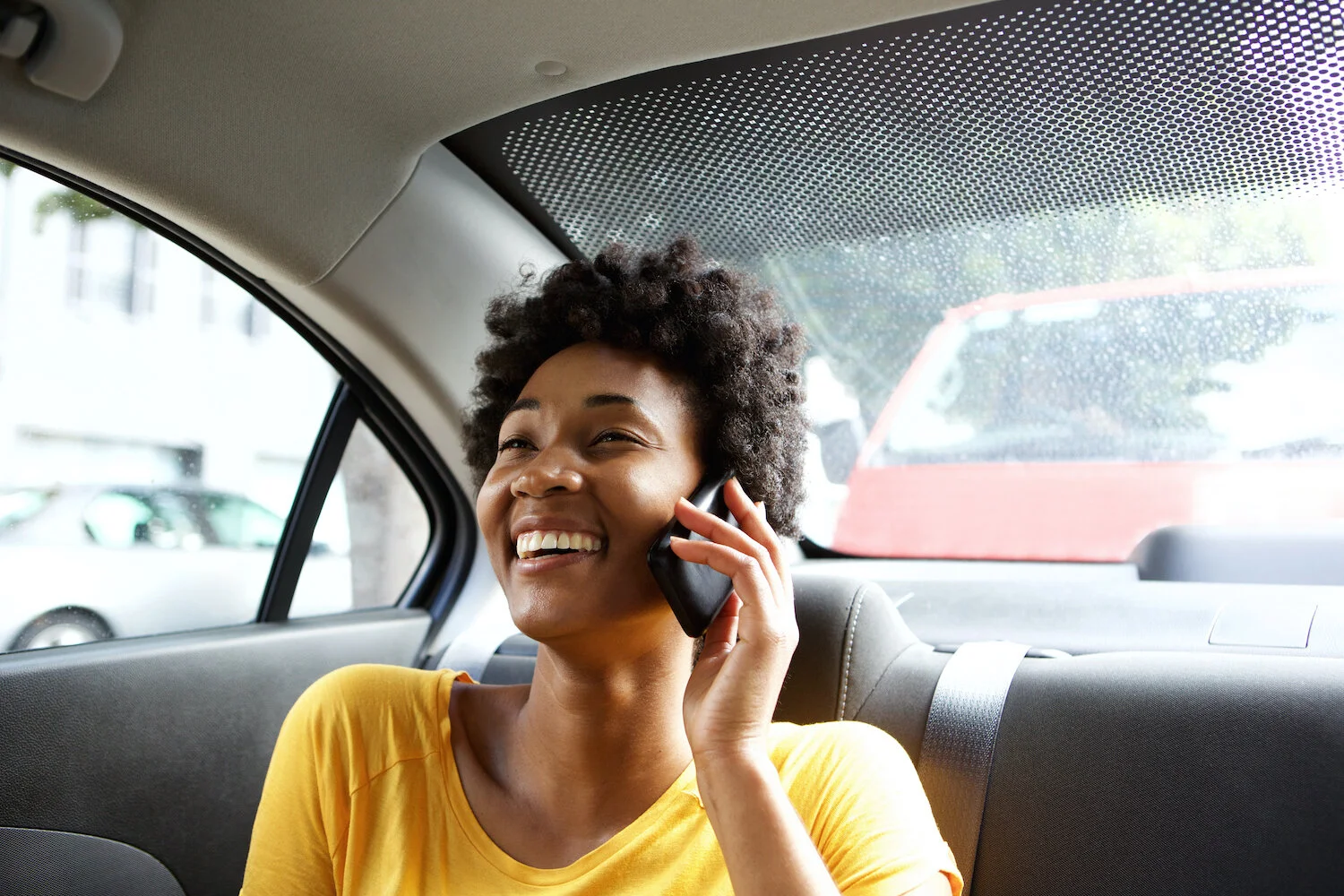 smiling-woman-in-a-car-talking-on-mobile-phone-PVJVLJ4.jpg