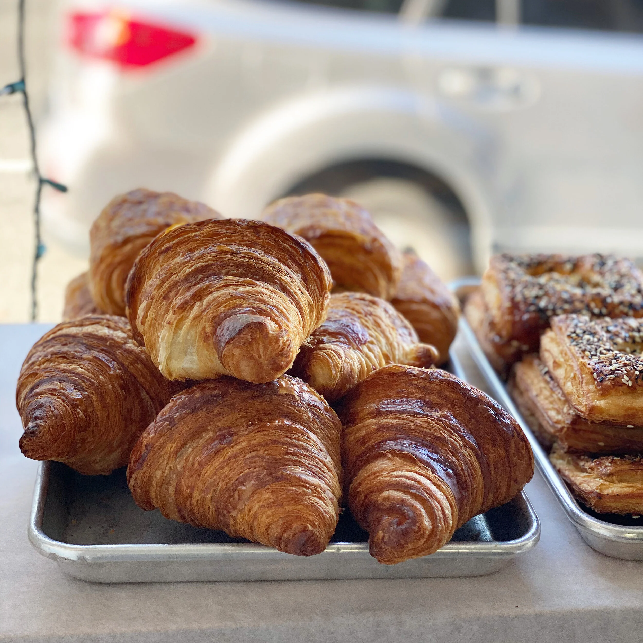 an abundance of croissants in a bright window display