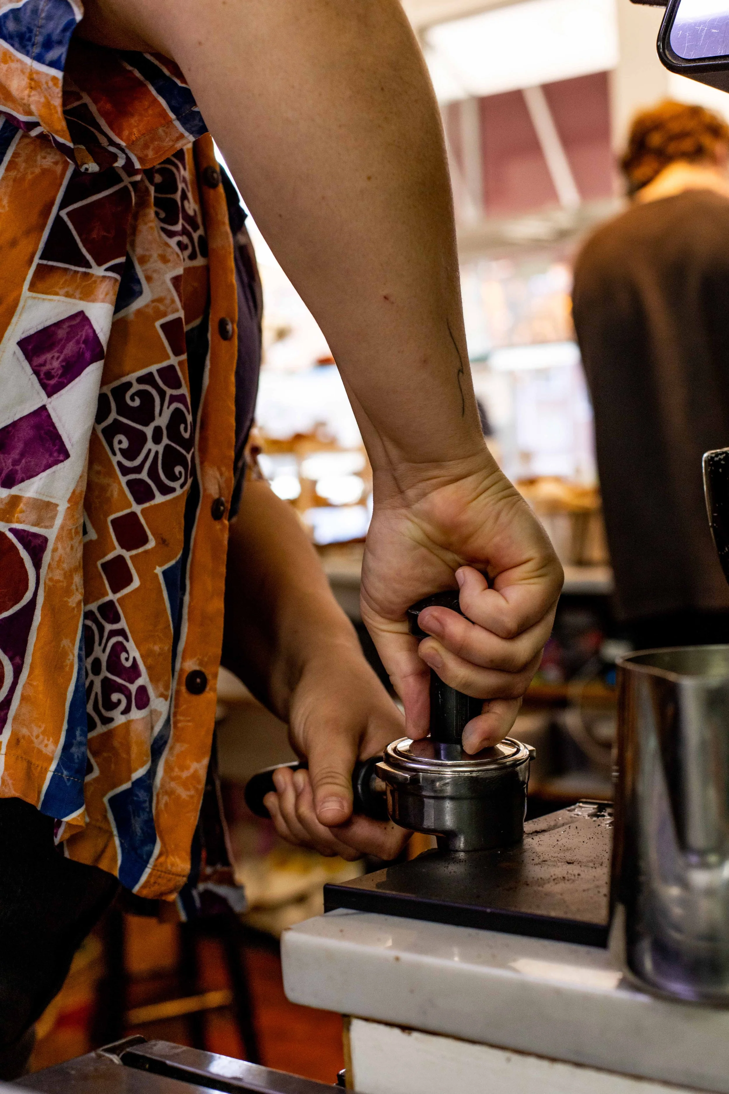 a barista tamping an espresso shot