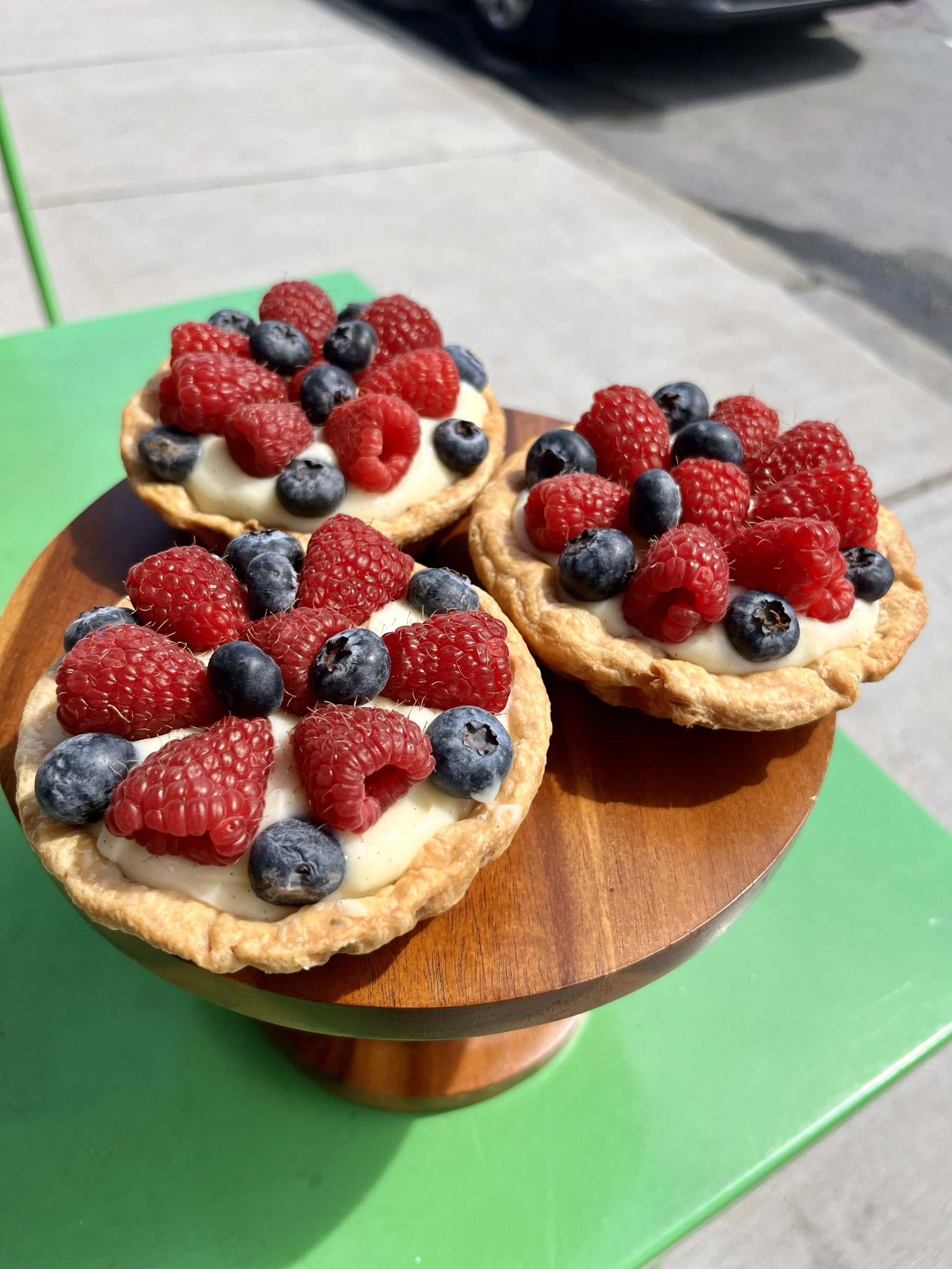 fruit tarts on display in the sunshine