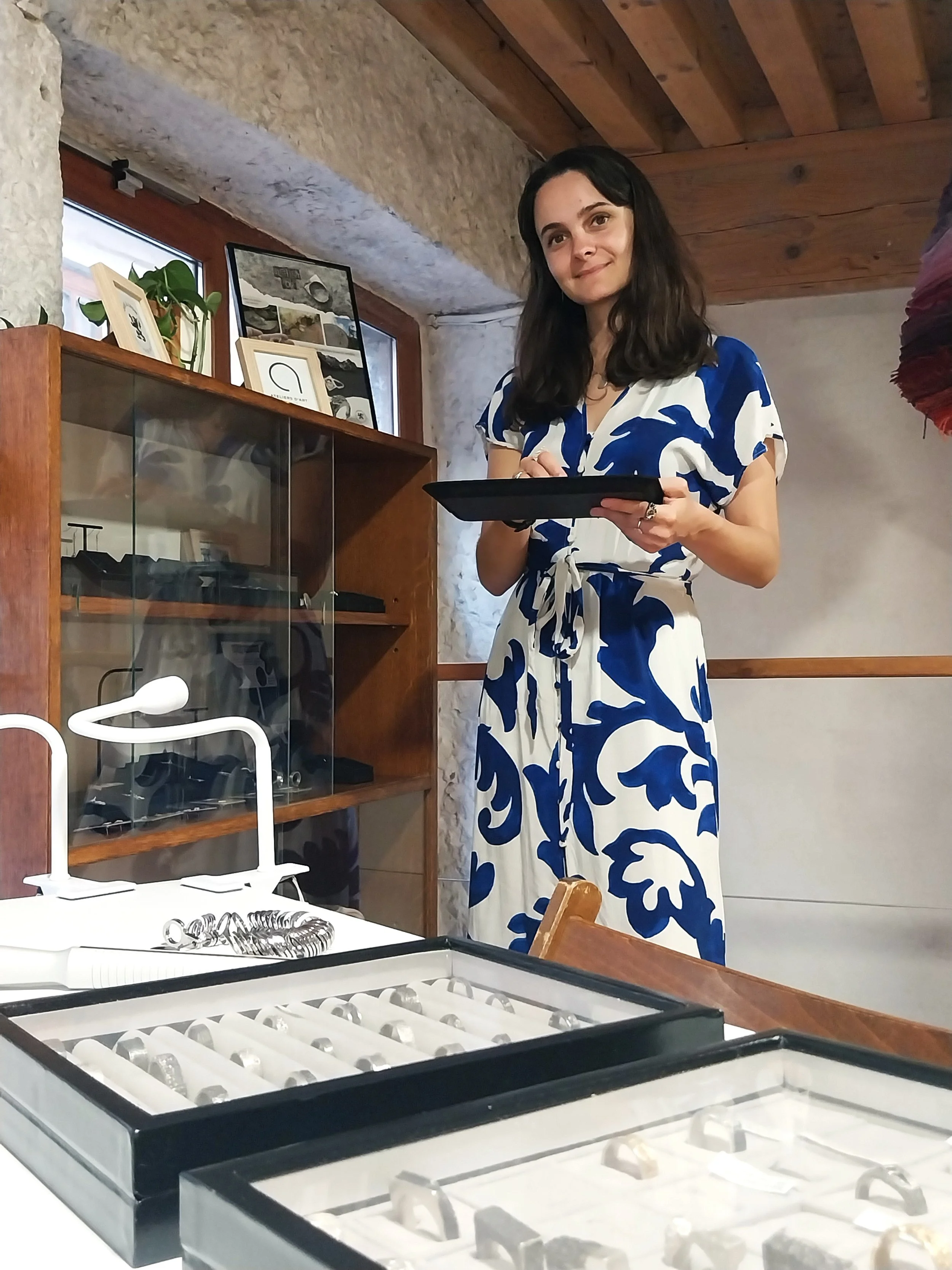Bijoutière sur mesure présentant son travail dans le bureau où elle reçoit ses clients.