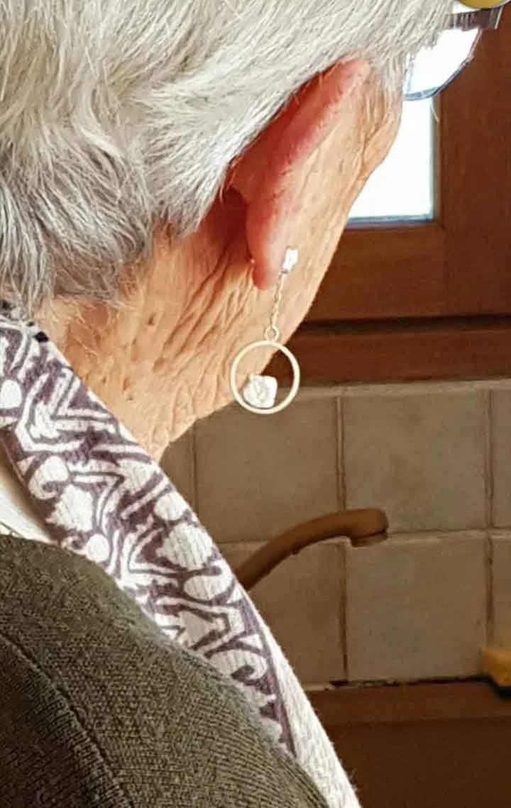 Grand-mère avec des boucles d’oreilles en argent recyclé aux motifs texturés. Pièces artisanales portées au quotidien, réalisées à la main dans un atelier de création lyonnais.