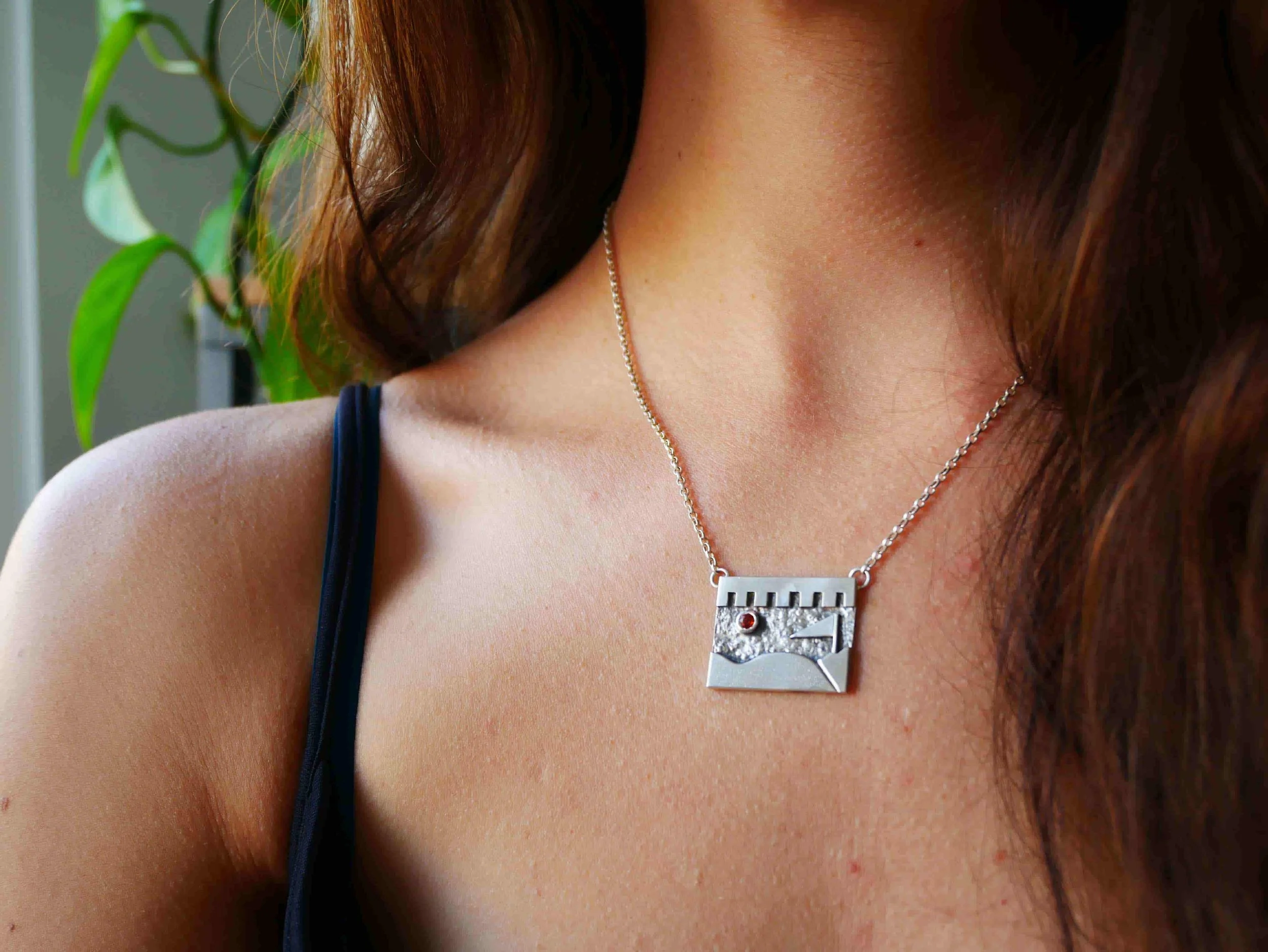 Pendentif argent sur-mesure avec pierre orange sertie, inspiré d’un tableau d’artiste plasticienne. Bijou souvenir unique, aux textures fines, reproduction fidèle d’un collage chargé de sens et d’émotion.