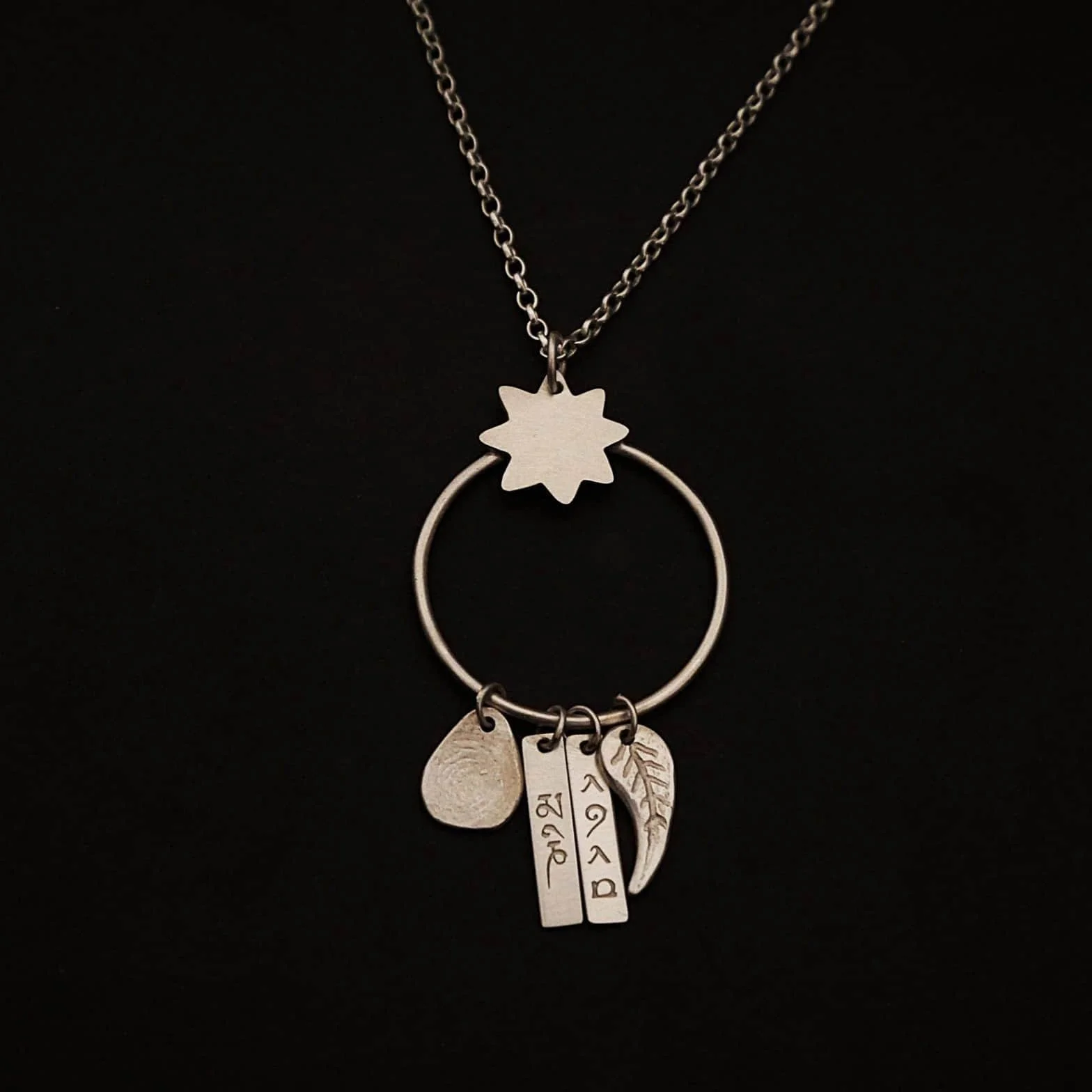 Collier sur mesure pour femme en argent sur fond noir.
