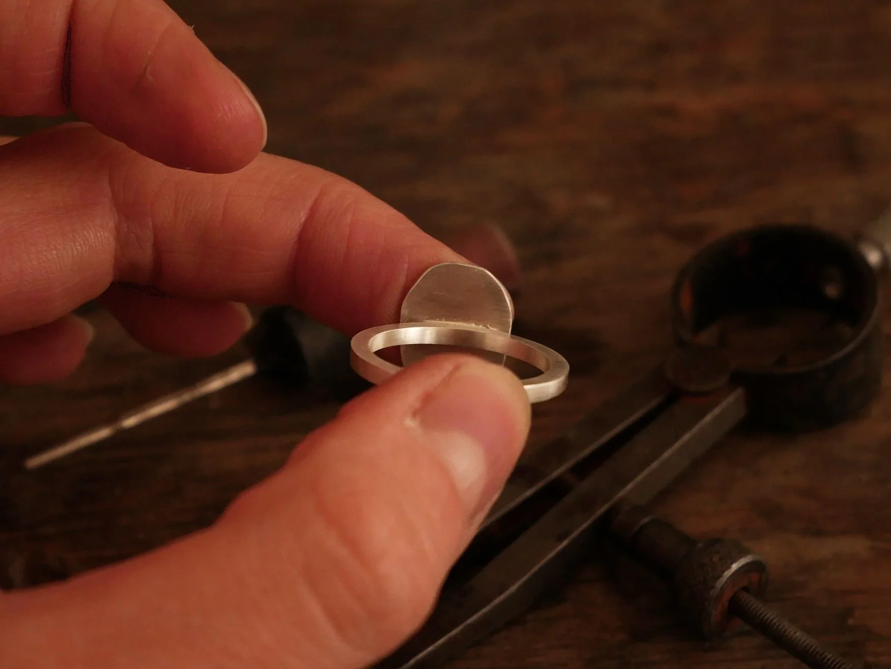 Vue arrière d’une bague empreinte en argent, montrant la soudure de l’empreinte digitale sur l’anneau, bijou sur-mesure fabriqué par une bijoutière artisanale, création authentique chargée d’émotion