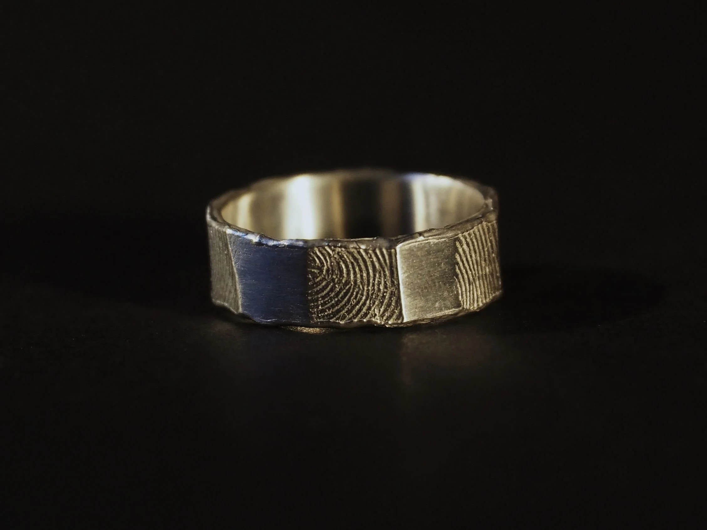 Bague empreinte en argent à rebord fondu sur fond noir, bijou sur-mesure et authentique signé Atelier 962°, bijou empreinte de doigt évoquant émotion, souvenir et lien éternel.