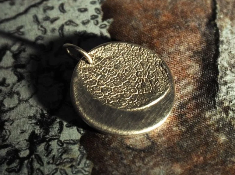 Collier sur mesure avec l’empreinte du museau d’un chien. C’est un collier sur mesure, la cliente souhaitait que l’empreinte de la truffe ne recouvre pas l’entièreté du médaillon afin de laisser apparaître une lune.