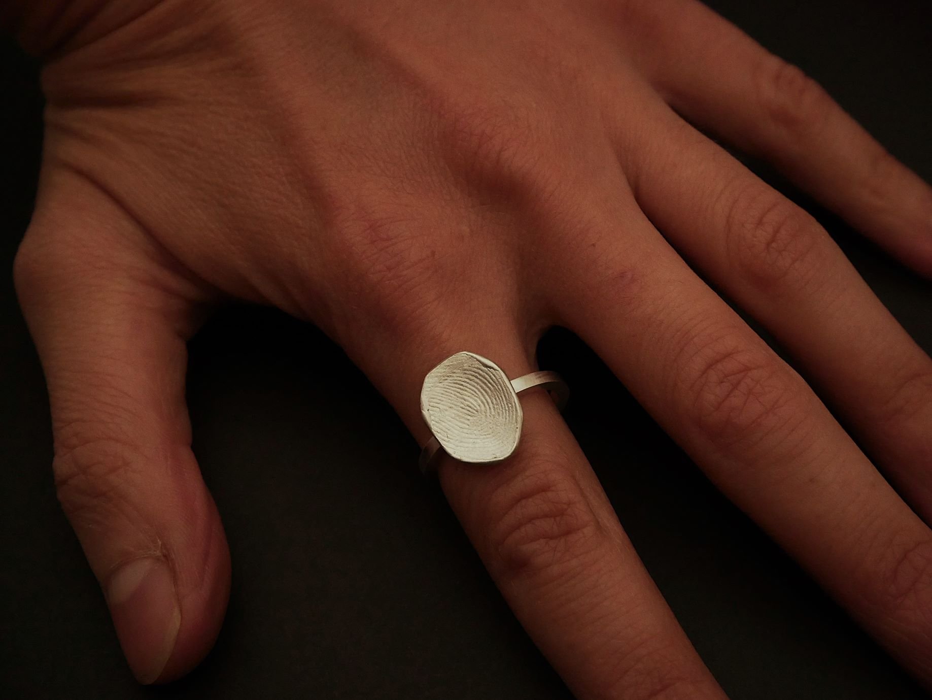 Bague empreinte de doigt en argent portée sur une main, bijou sur-mesure et authentique signé Atelier 962°, création artisanale lyonnaise, symbole d’attachement et bijou sentimental unique.