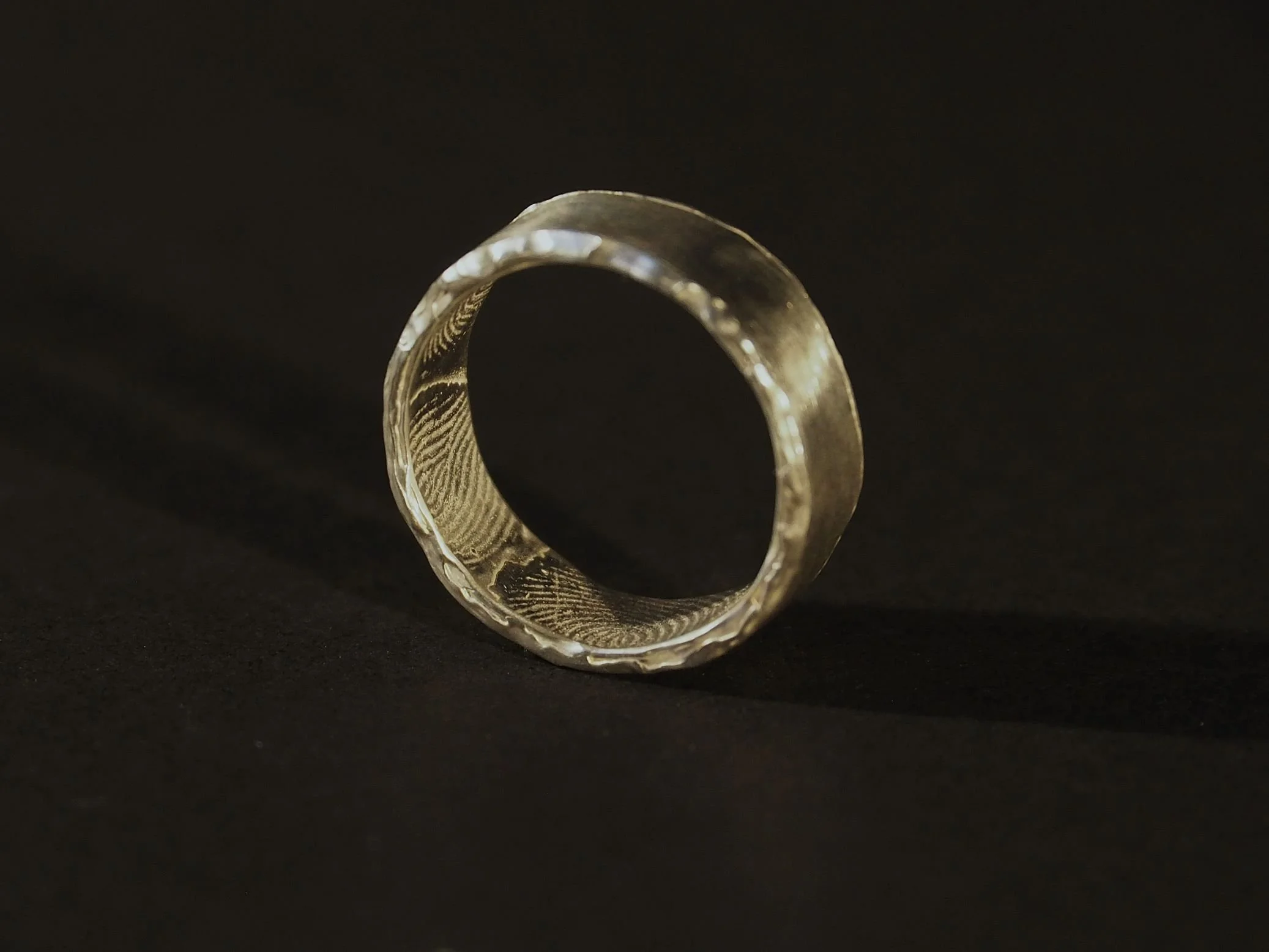 Bague empreinte digitale en argent avec rebord fondu, anneau lisse et intérieur gravé, bijou empreinte sur-mesure Atelier 962°, création artisanale symbole de souvenir et d’amour durable.