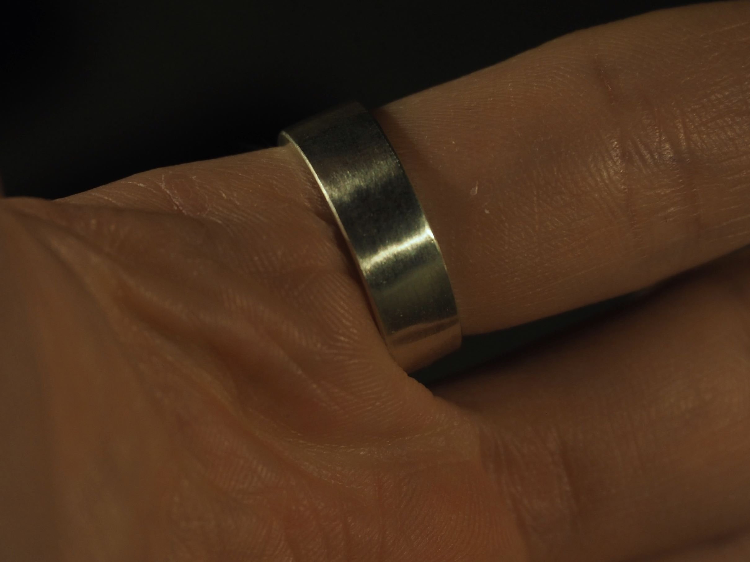 Bague empreinte digitale en argent portée sur main d’homme, bijou empreinte sur-mesure et élégant, anneau intérieur gravé, création artisanale Atelier 962°, symbole d’attachement sincère.