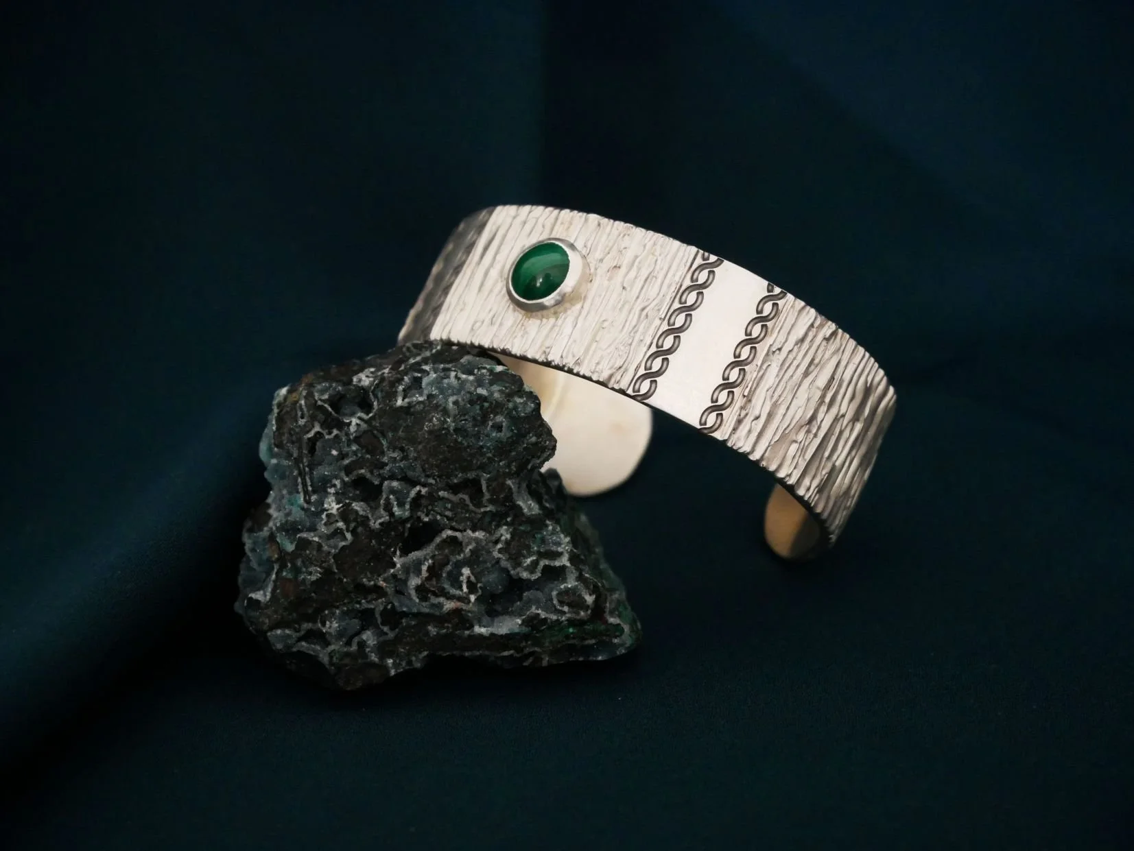 Bracelet en argent avec une pierre verte, une malachite. Ce bracelet jonc est très large et texturé avec des gravures torsadées.