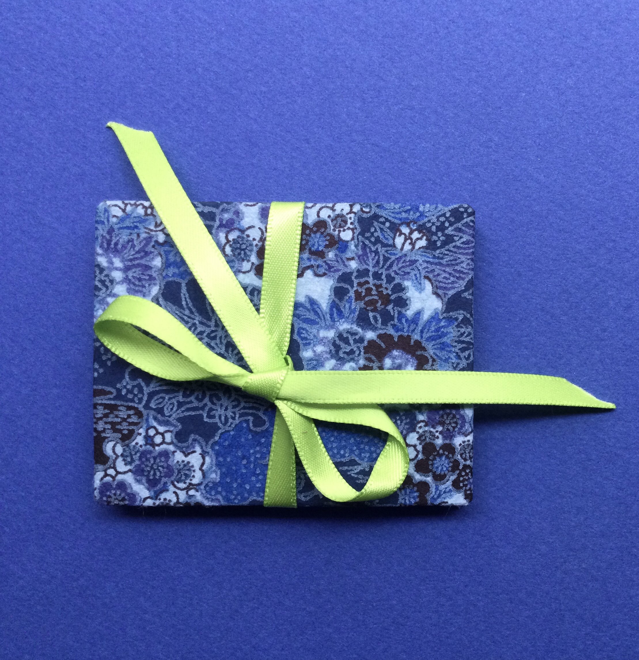 Closed miniature book showing Japanese paper and ribbon binding