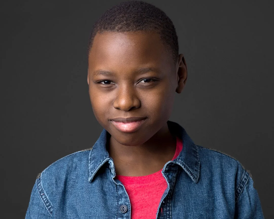 Headshot a child actor wearing a red shirt and denim jacket