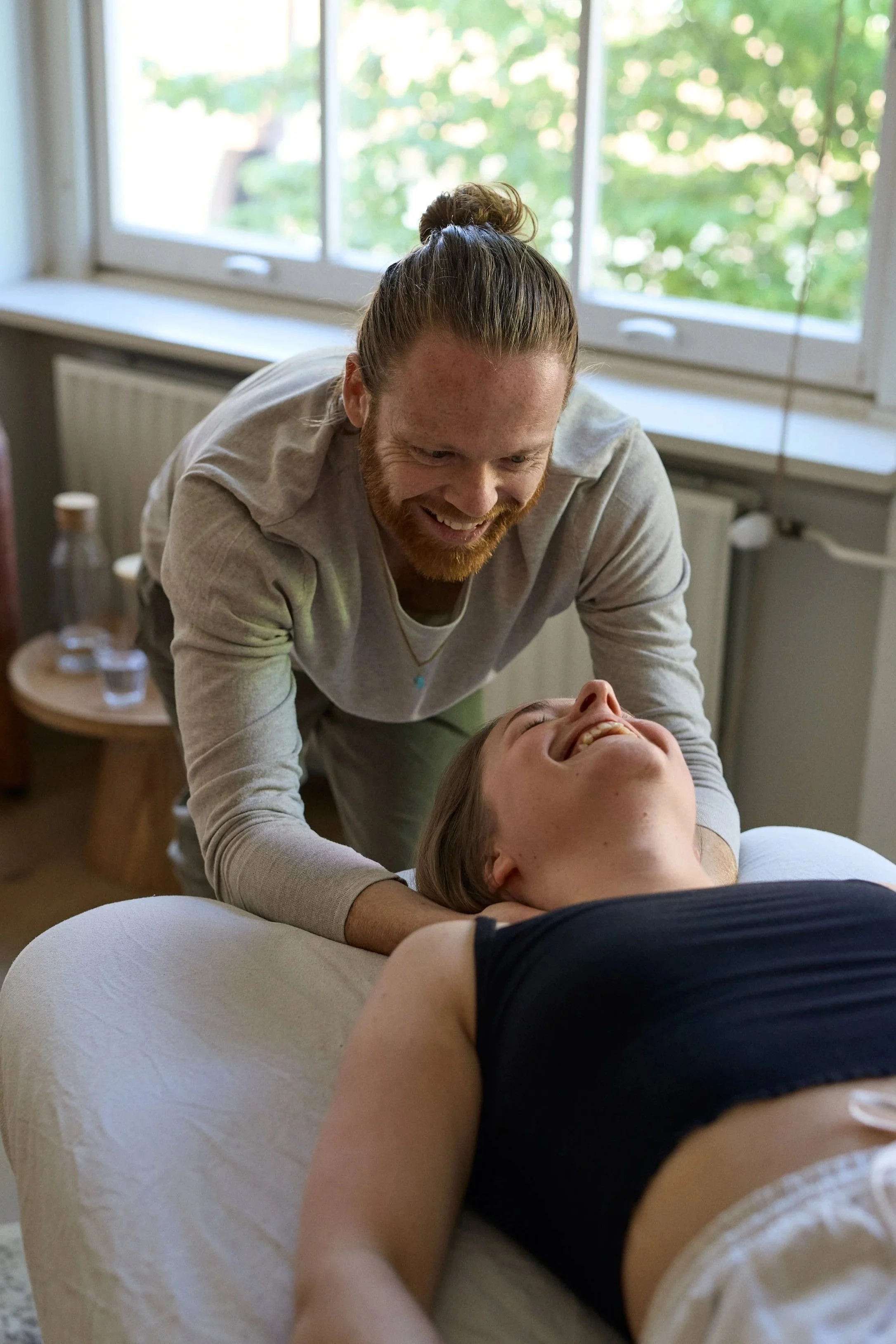 Picture of Leander Ruivenkamp working on a woman's neck and shoulders in a bodywork session.