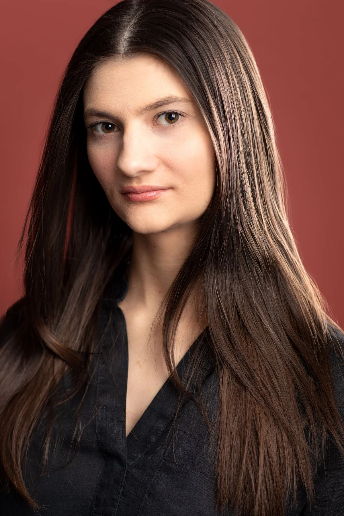 Dramatically lit actor headshot photographed by Hancock Headshots in NYC of woman with long hair 