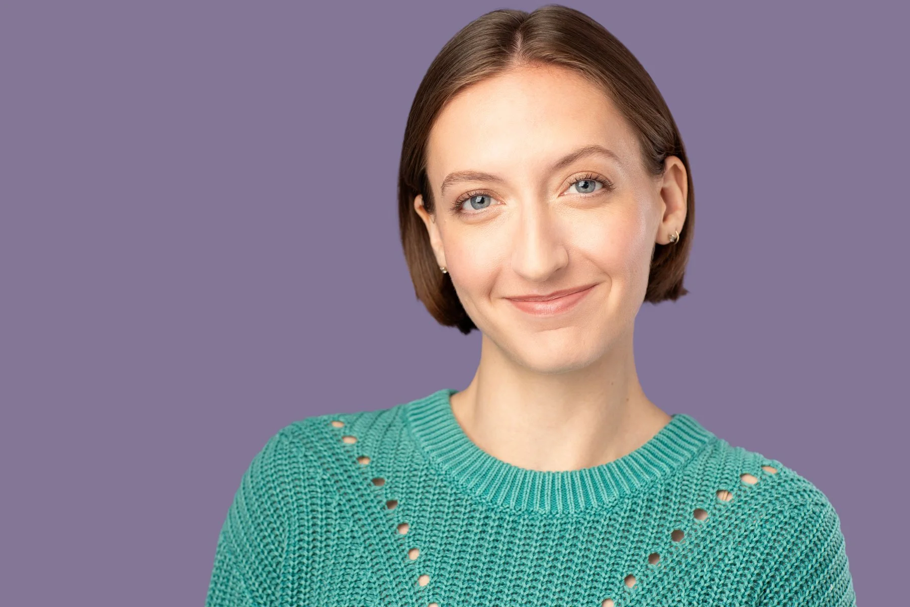 Actor headshot photographed by Hancock Headshots in NYC, commercial shot of woman smiling against purple backdrop 
