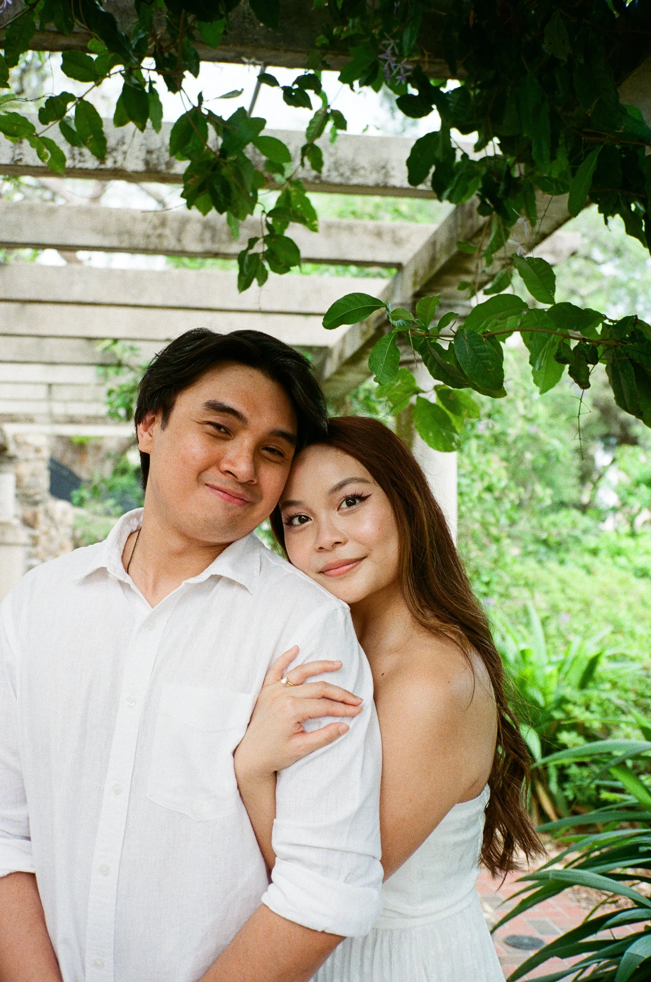 Couple embracing in the gardens of the Cummer Museum, captured on film.
