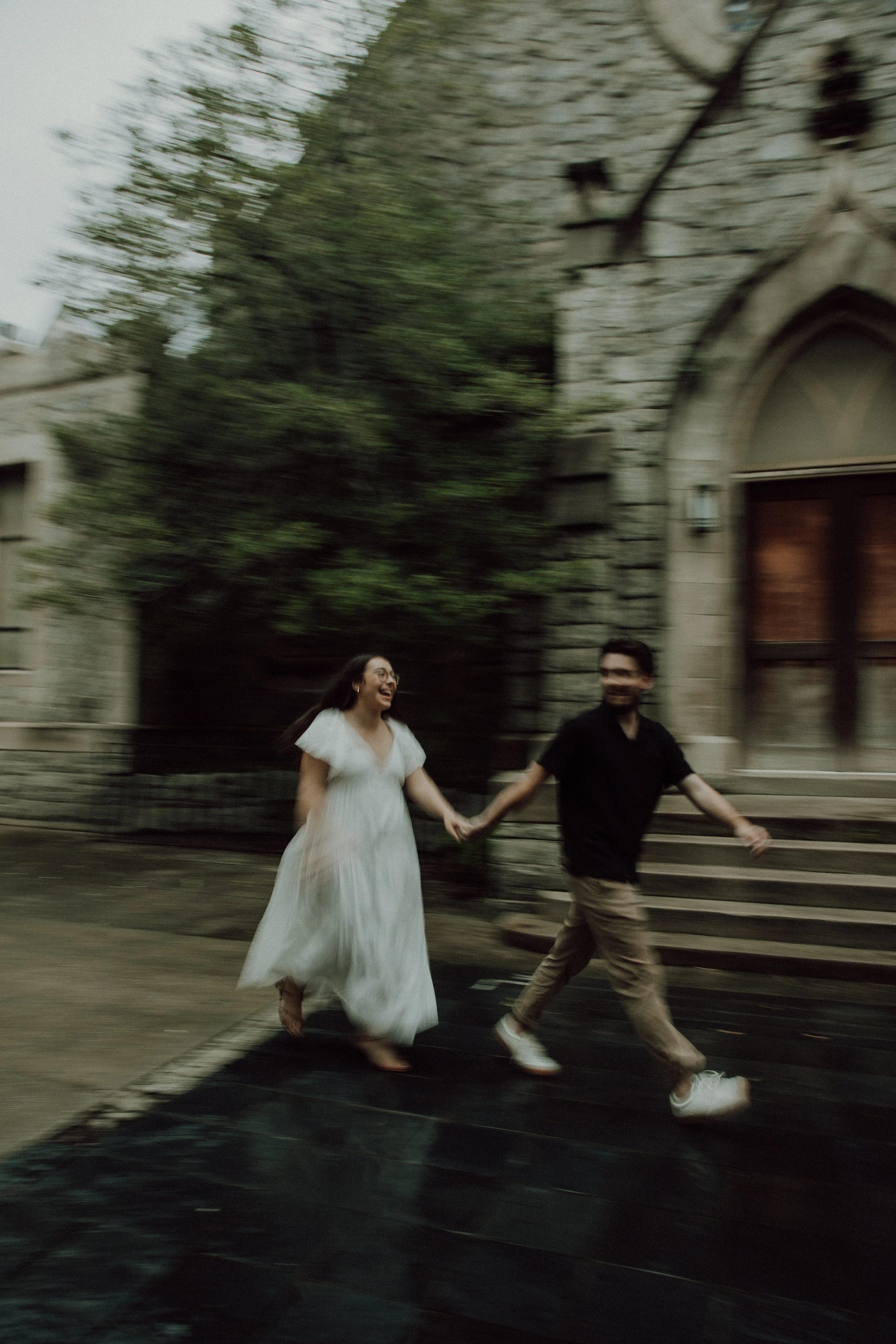 Couple walking through downtown streets during a candid engagement session.