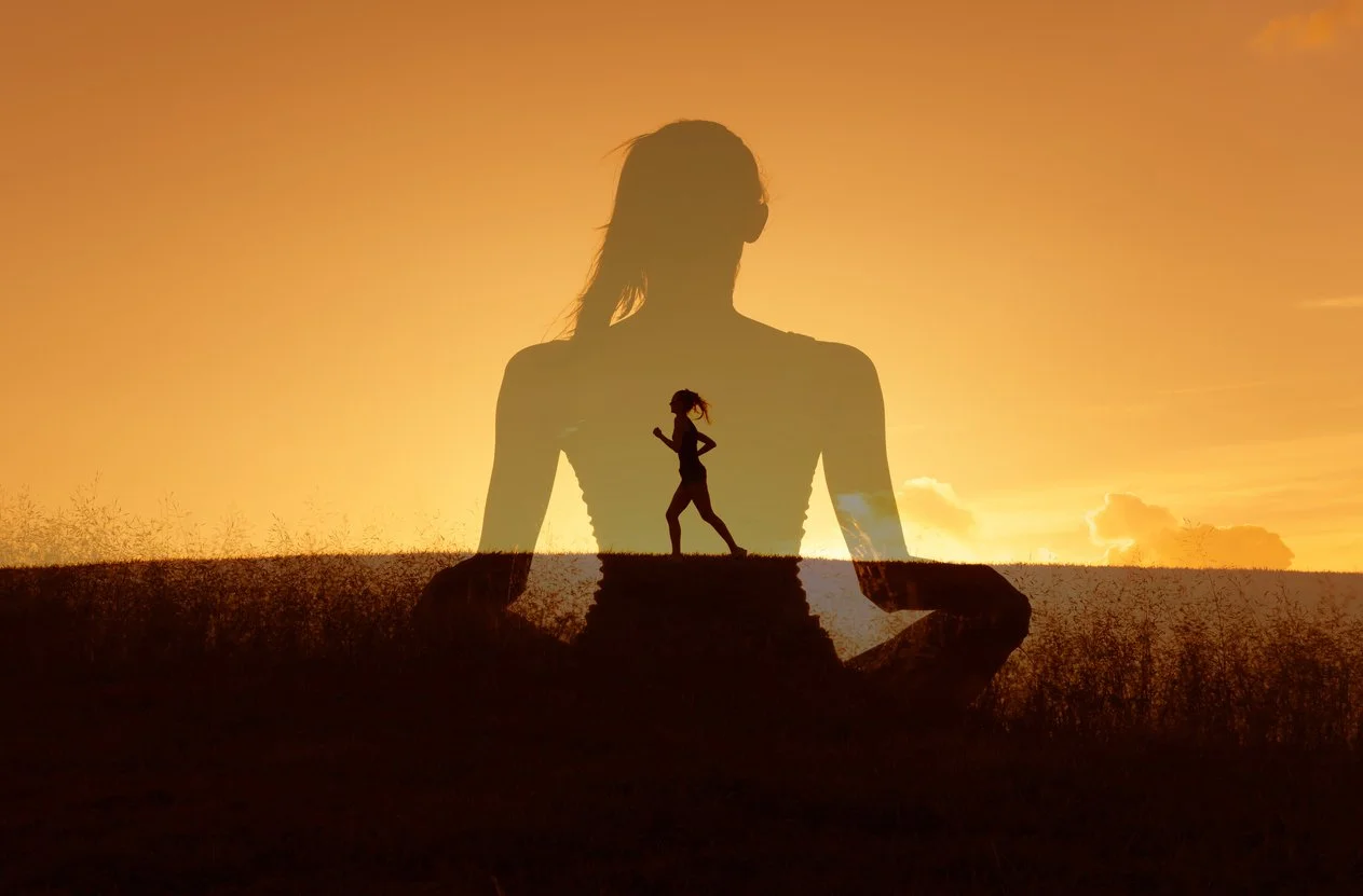 Silhouette of a woman sitting cross legged watching the sunset with a profile of herself going for a run across a grassy hill.