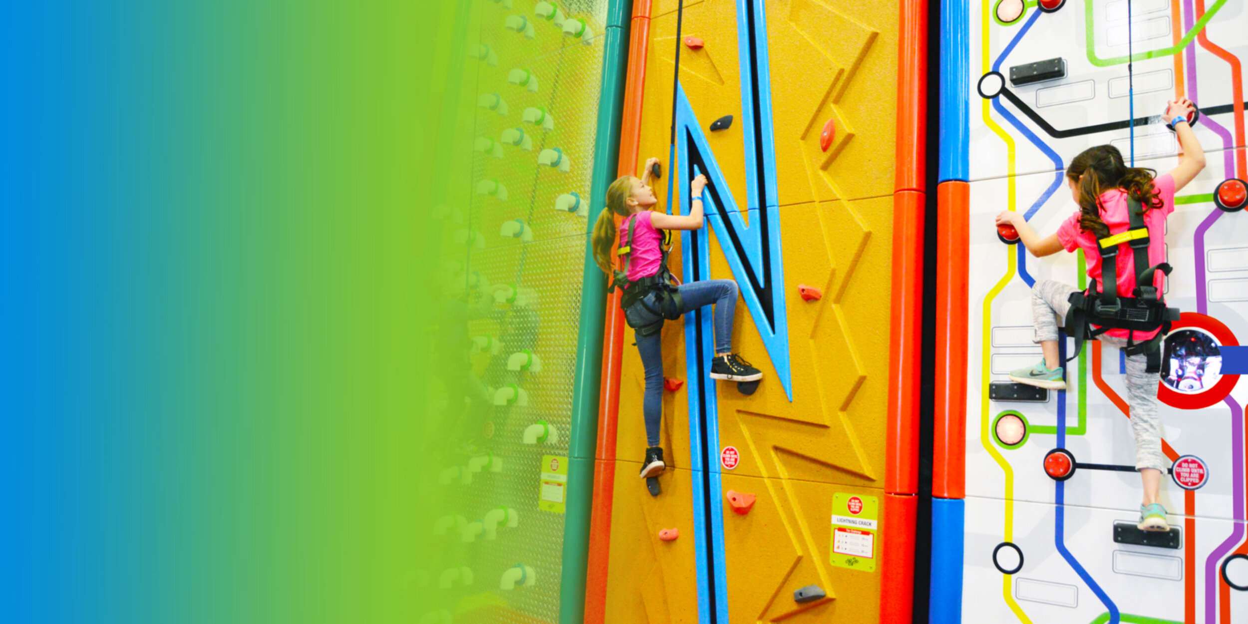 Girls climbing colorful Clip and Climb walls