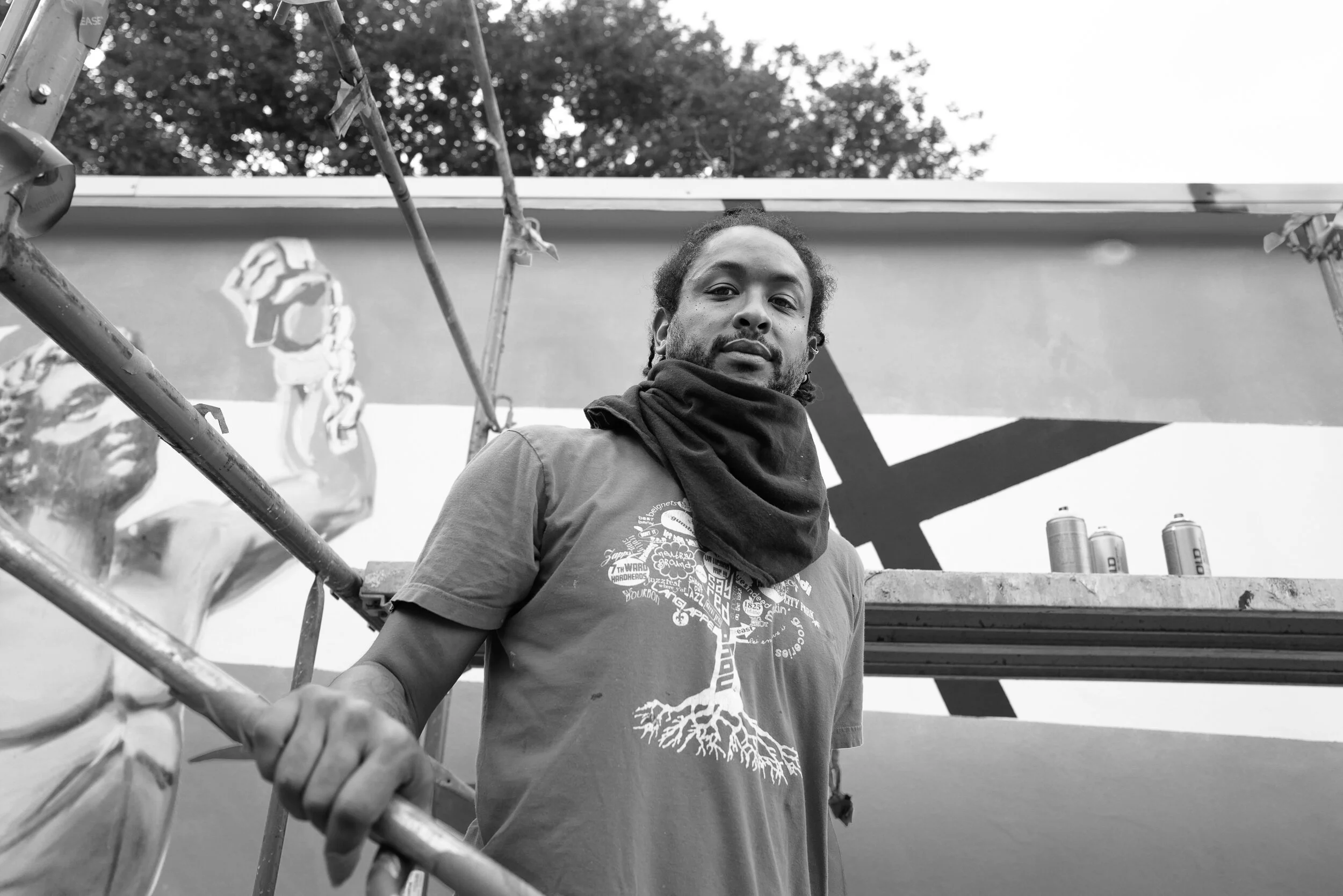 Artist, Ayo Scott, painting a mural honoring Civil Rights history along the newly rededicated Homer Plessy Way