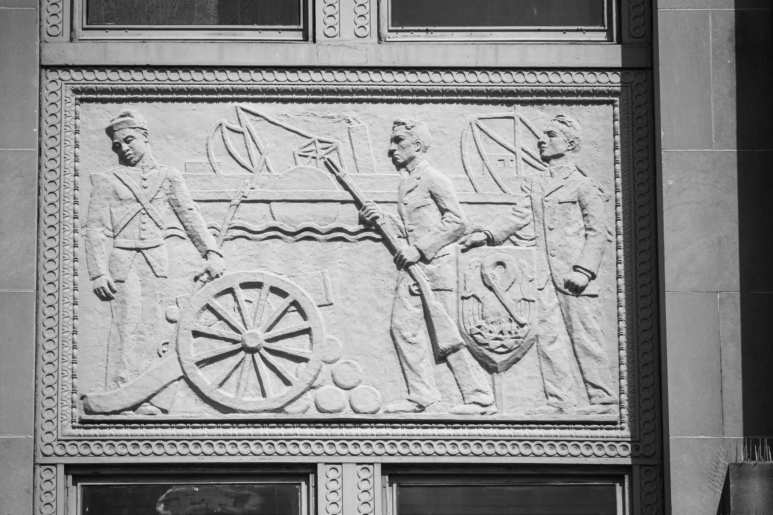 A Bronze relief statue on the façade of the Criminal District Court building, "Illustrates the [1874] uprising of the White League against the Metropolitan Police" depicting "[a]n African American policeman lay[ing] his rifle against an artillery pie