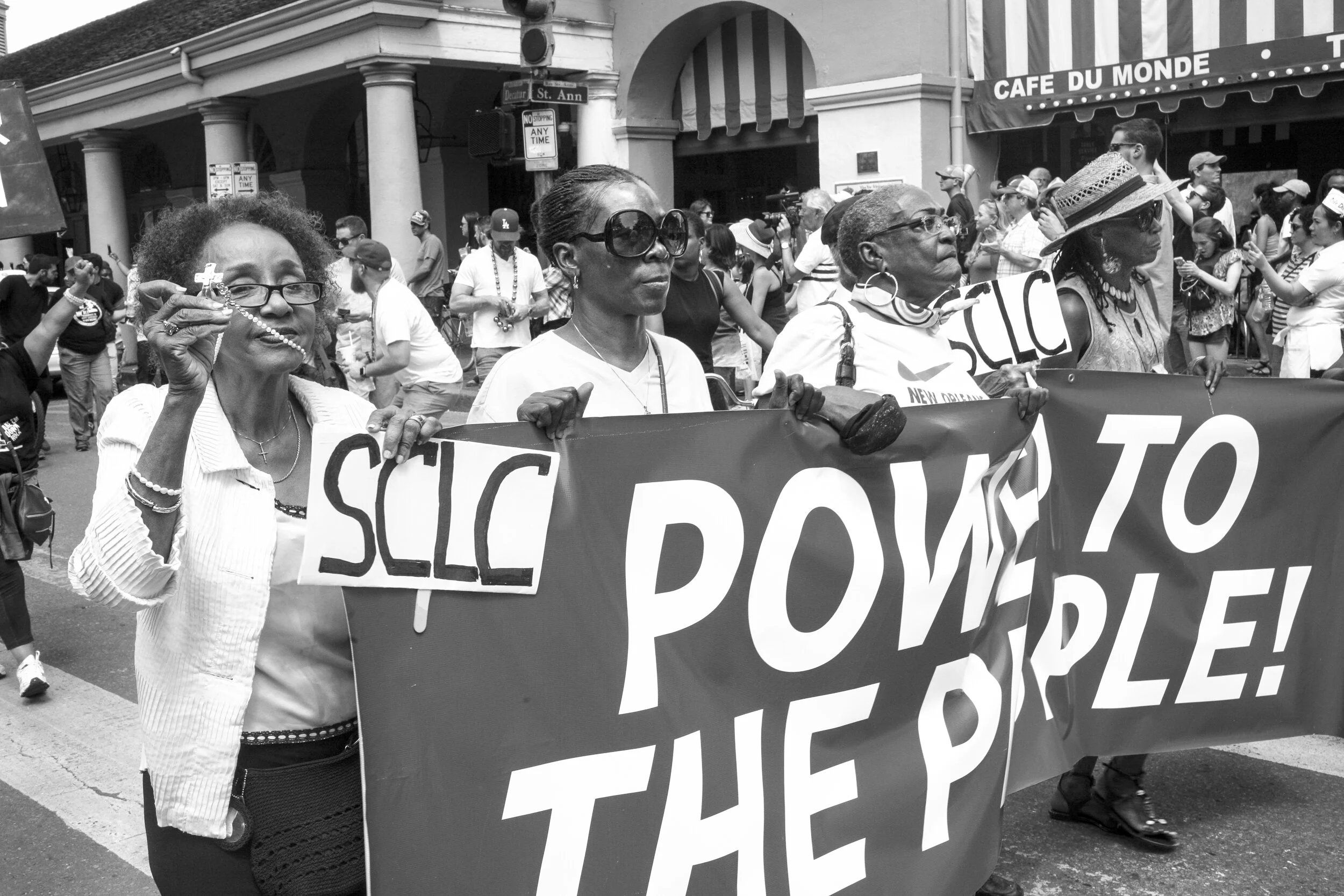 Women holding a sign of the Southern Christian Leadership Conference participating in a march to remove monuments of white supremacy.  New Orleanian activists were an integral part of the early development of the SCLC coinciding with Dr. Martin Luthe