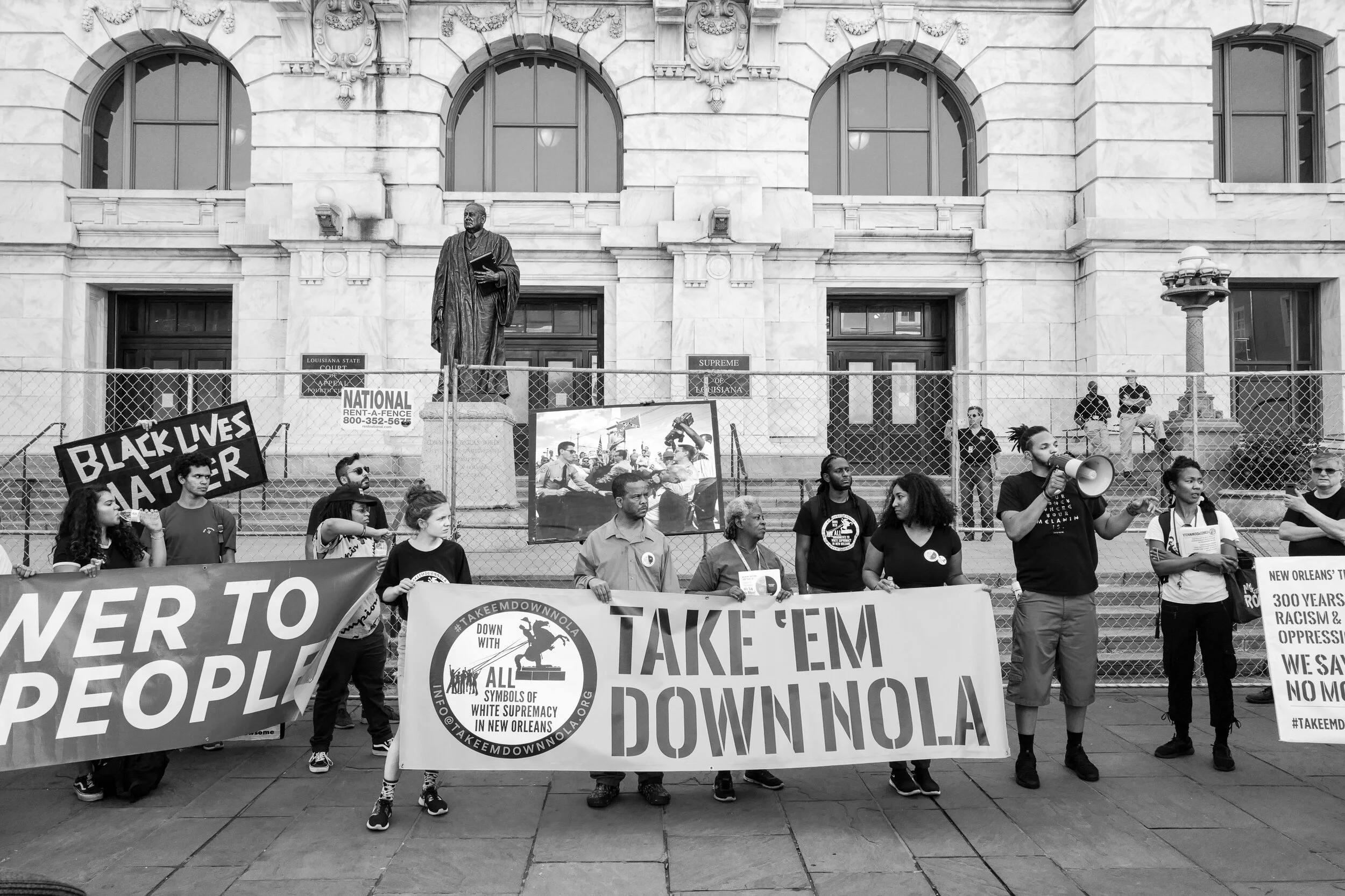 An activist with Take 'Em Down NOLA speaking to the crowd about the racist legacy of E.D. White during a protest to address the remaining tributes to white supremacy in the city