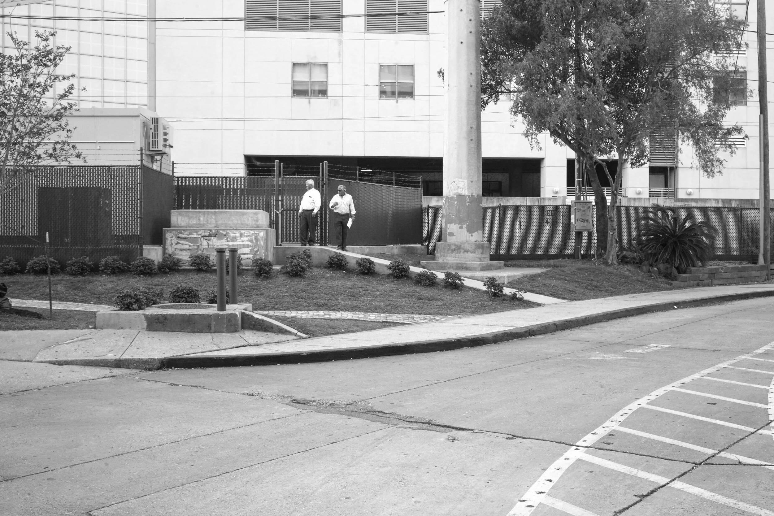 Frustrated men reviewing property line documents at the empty plinth of "Battle of Liberty Place" monument, the day following its removal