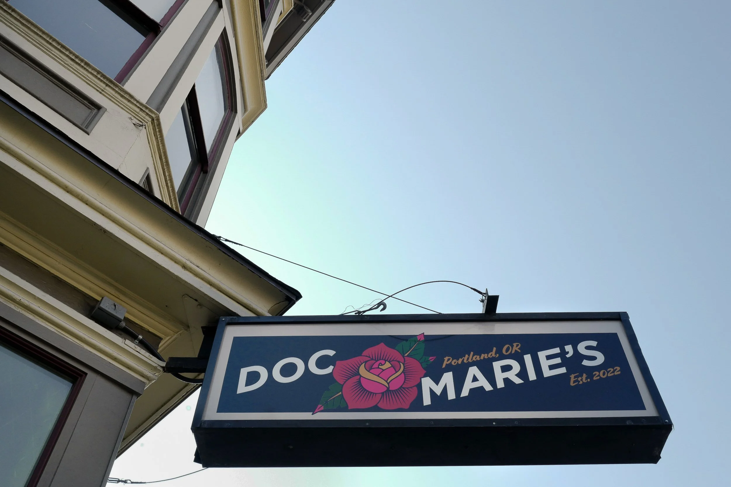 Dr. Marie Equi—Sign above the entrance to “Doc Marie's,” an LGBTQ+ bar named in honor of the Portland labor and women's rights leader.  One of Oregon's earliest female physicians, the social activist became a prominent local leader with the Internati