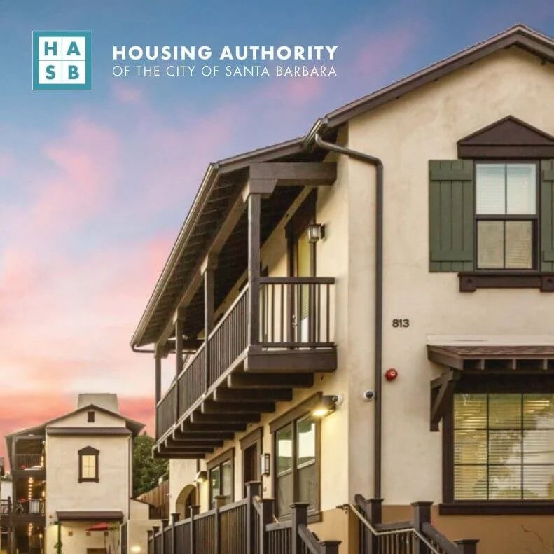 Exterior view of multi-story residential buildings under a pink and blue sunset sky, featuring balconies, green window shutters, and a fence, with the logo of the Housing Authority of Santa Barbara in the top left corner.