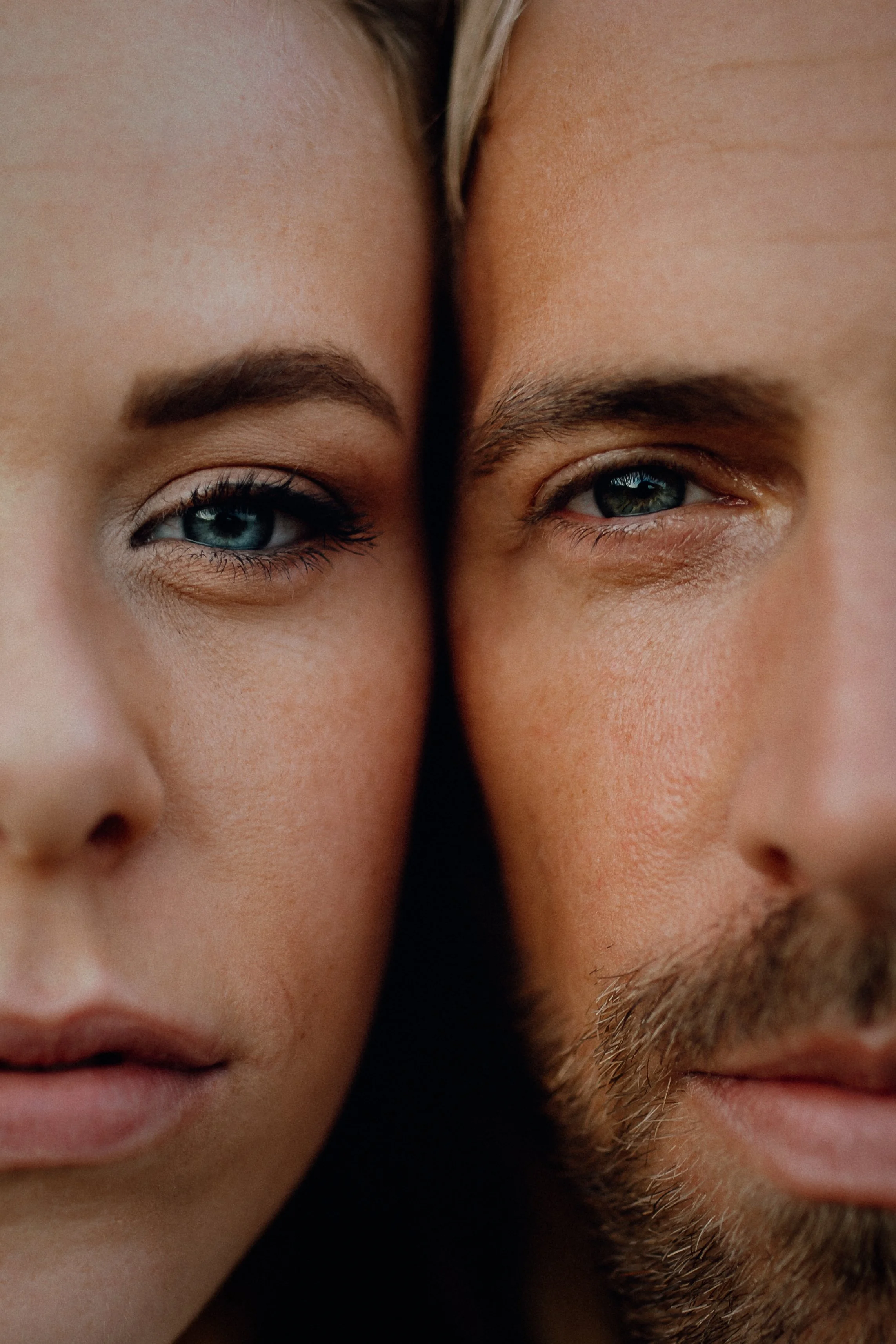 Nahaufnahme der Gesichter eines Mannes und einer Frau, die sich sehr nahe kommen, beide mit blauen Augen, sichtbare Hauttextur und Haarpartien.