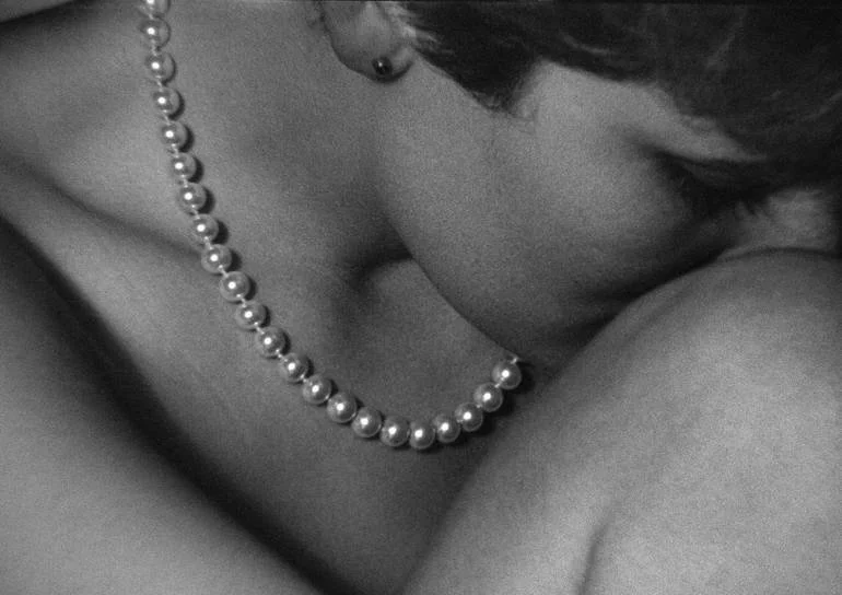 Abstract Body Landscapes. Retro Collection. Close-up of a woman with short hair, wearing a pearl necklace and earrings, resting their face on their arm in a black-and-white photo. Artist Czar Catstick BFA Hub Online British Bespoke Fine Art Gallery F