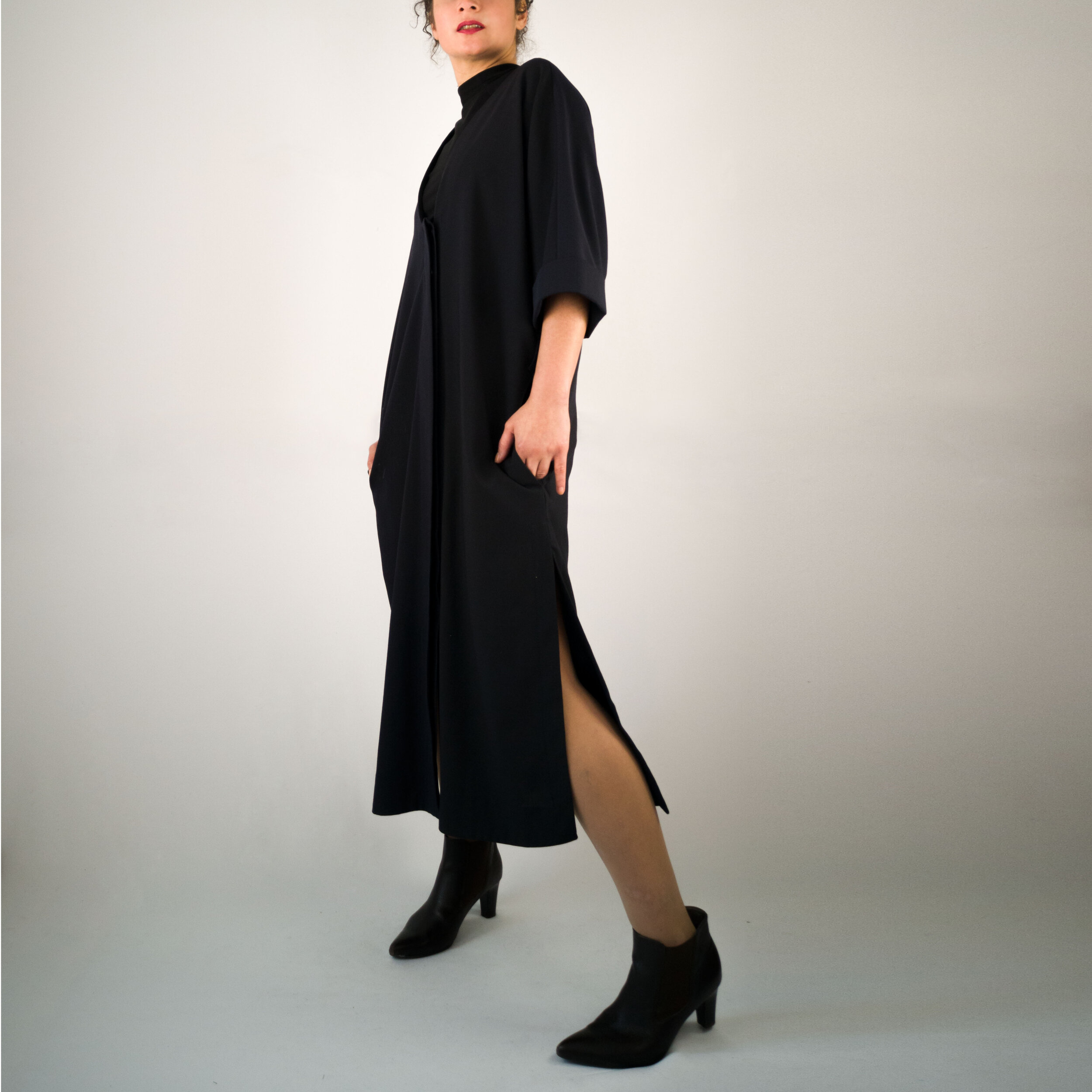 Langes Mantelkleid mit seitlichen Schlitzen und verdeckter Knopfleiste;seitliche Vorderansicht;hier ohne Gürtel;dunkelblau;Wollstoff;Taschen in der Naht;Steinnuss-Knöpfe;Leftover;made in Berlin