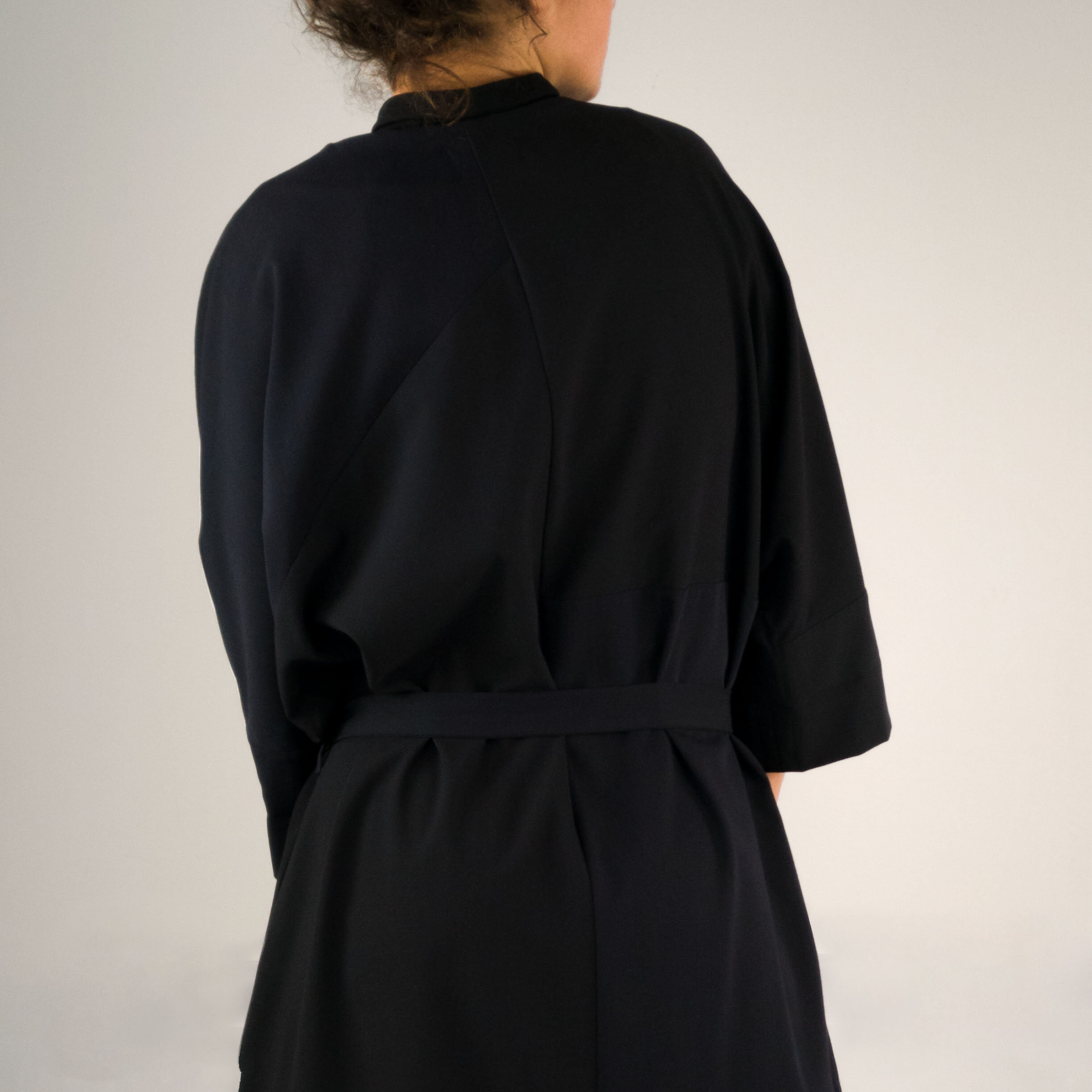Langes Mantelkleid mit seitlichen Schlitzen und verdeckter Knopfleiste;Rückenansicht Detail;mit Gürtel;dunkelblau;Wollstoff;Taschen in der Naht;Steinnuss-Knöpfe;Leftover;Slow Fashion made in Berlin