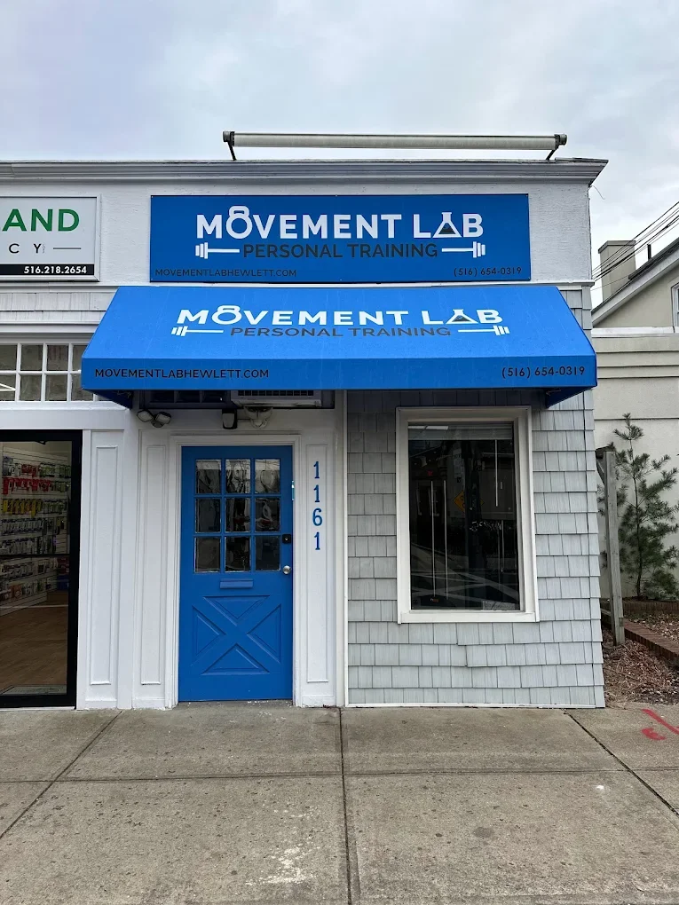 Exterior of a fitness center called Movement Lab Personal Training with a blue door and blue awning, located at 1161, on a sidewalk.